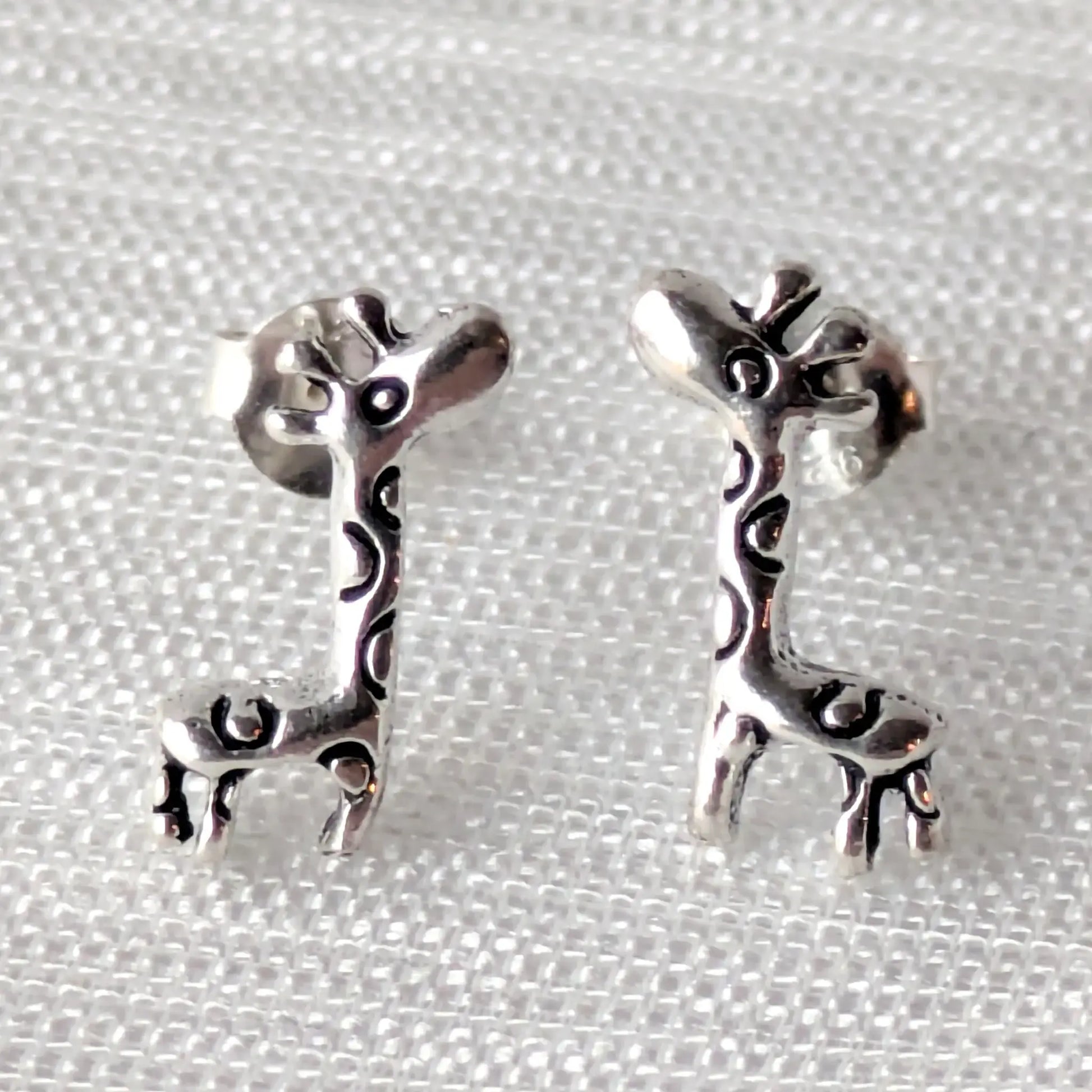 Silberne Giraffe-Ohrstecker aus 925 Sterling Silber auf hellem Hintergrund