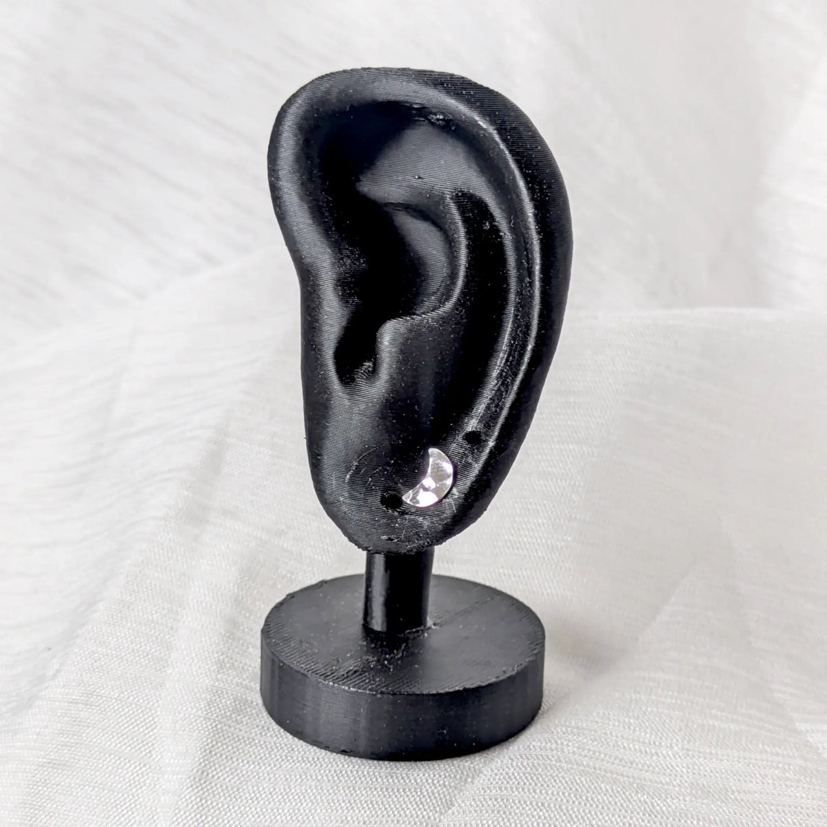 Silberne gehämmerte Mond Ohrstecker, präsentiert an einem schwarzen Ohr-Display zur Veranschaulichung der Proportionen.