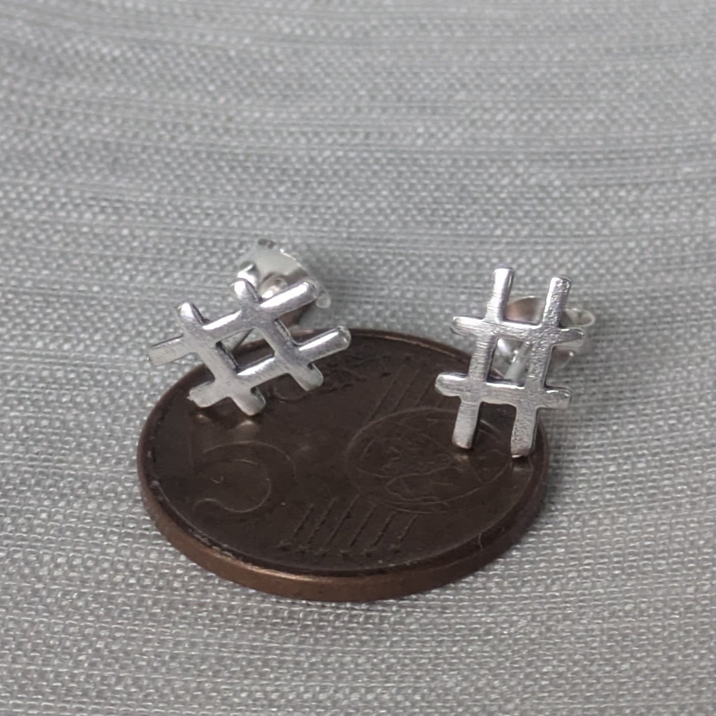 Größenvergleich der kleinen Hashtag-Silberstecker auf einer 5-Cent-Münze liegend.