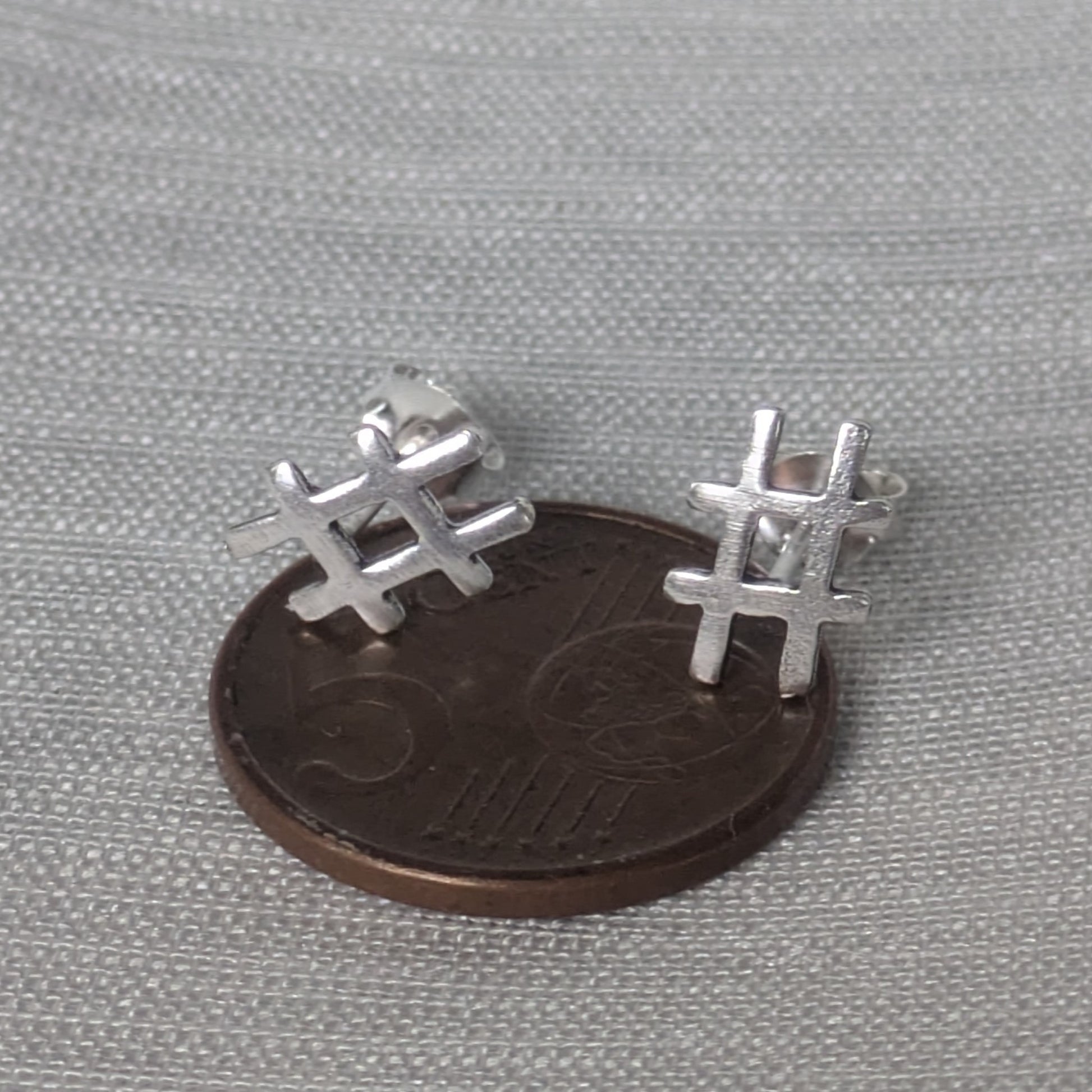 Größenvergleich der kleinen Hashtag-Silberstecker auf einer 5-Cent-Münze liegend.