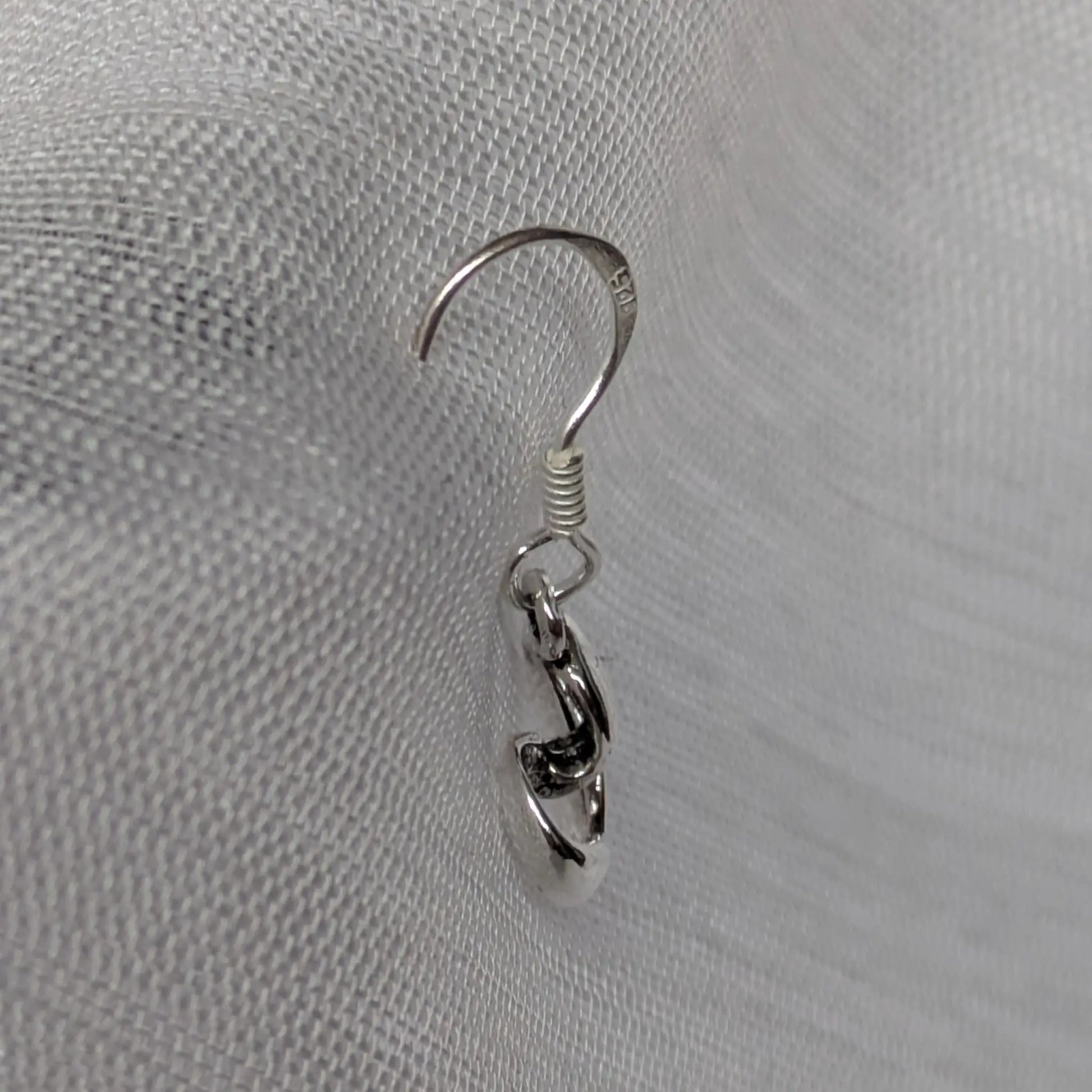 Seitenansicht der geschwungenen Herz-Ohrhänger aus Silber.