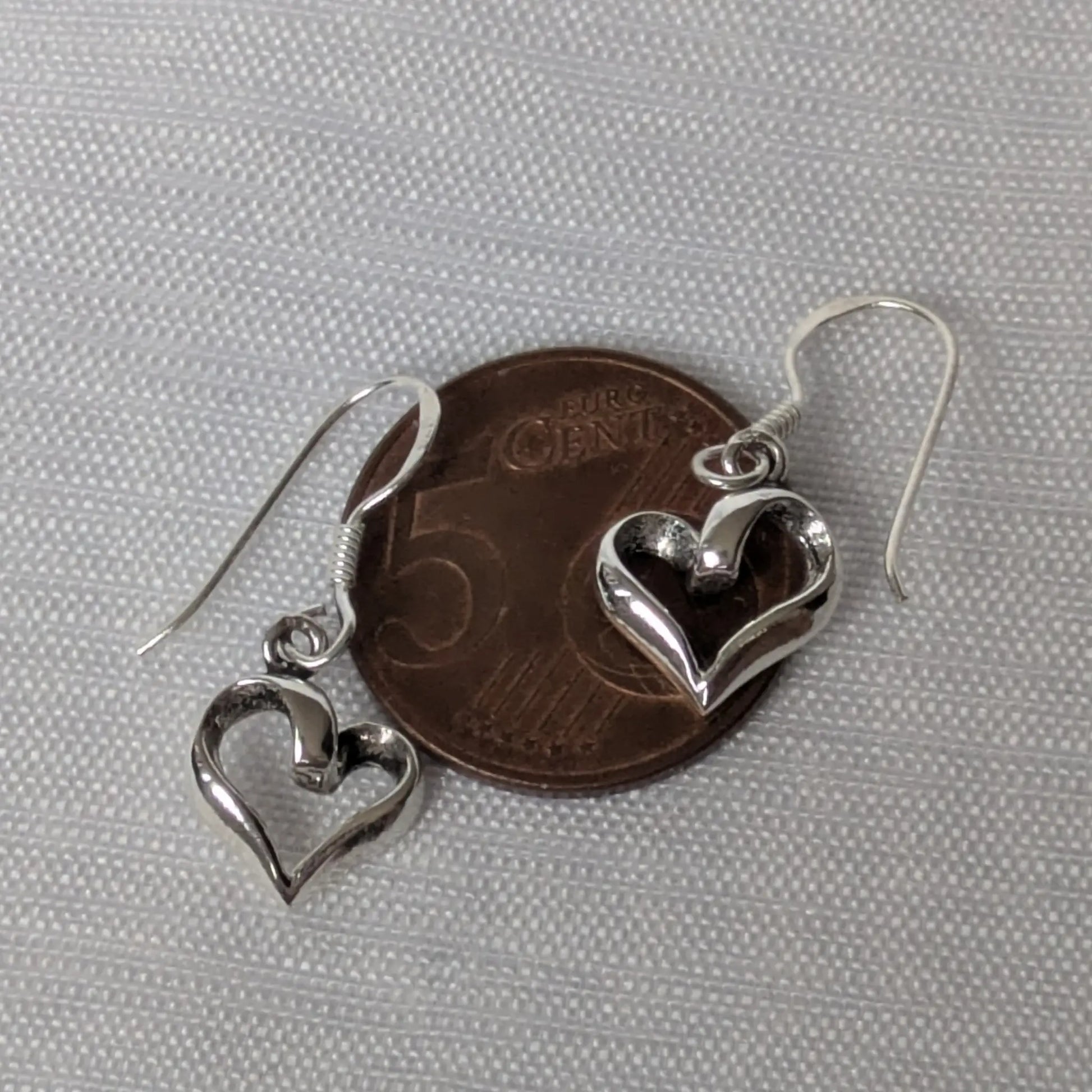 Größenvergleich der Herz-Ohrhänger auf einer 5-Cent-Münze.