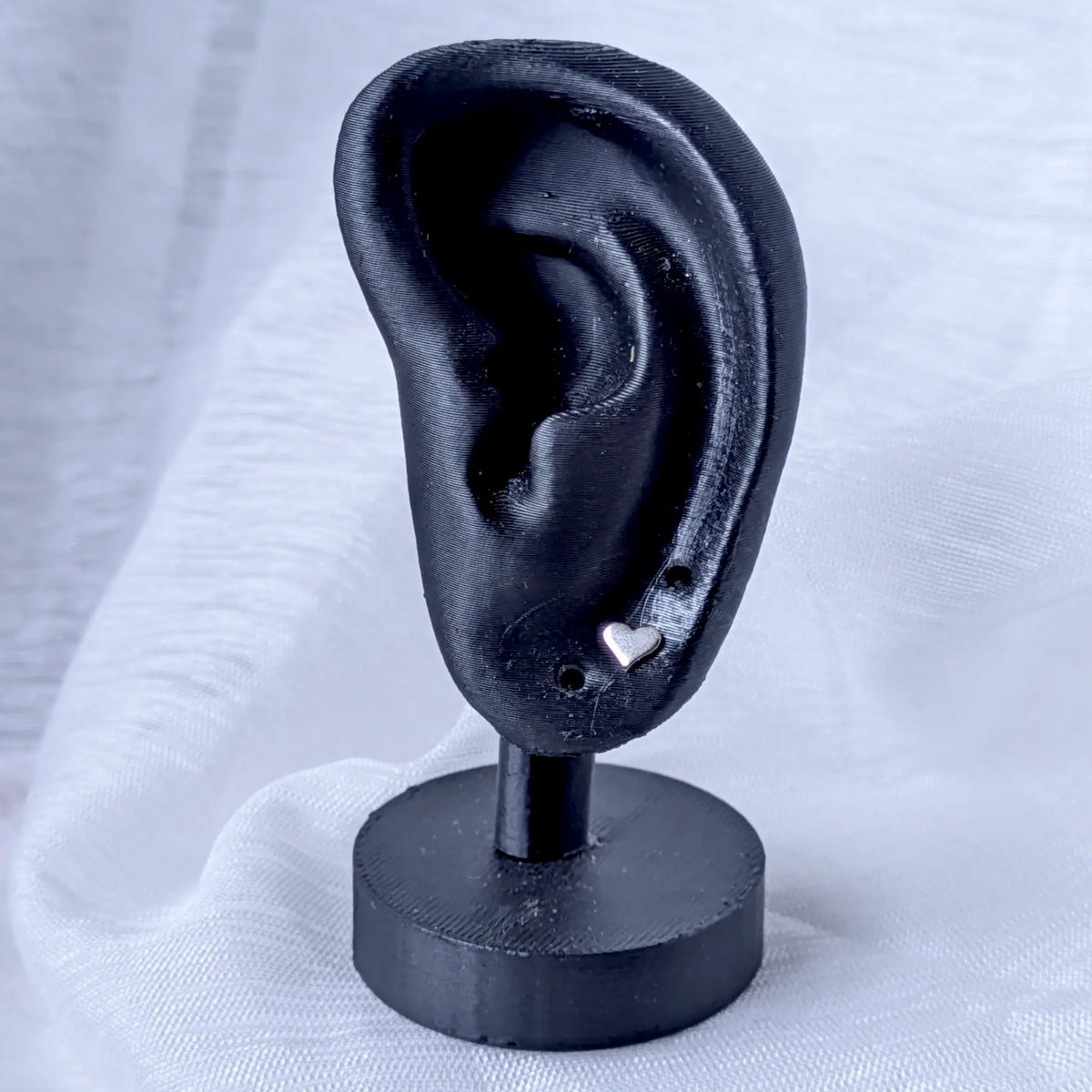 5mm Herz Ohrstecker aus 925 Silber präsentiert an einem schwarzen Ohr-Display.