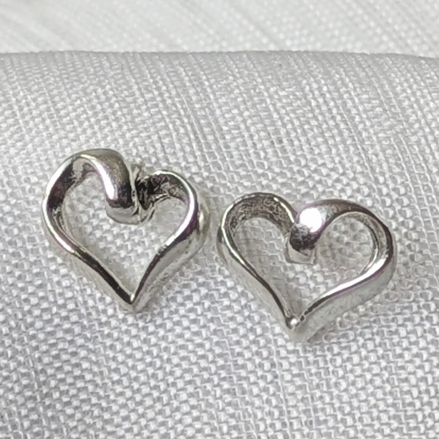 Nahaufnahme der geschwungenen Herz Ohrstecker aus hochglanzpoliertem 925 Sterling Silber
