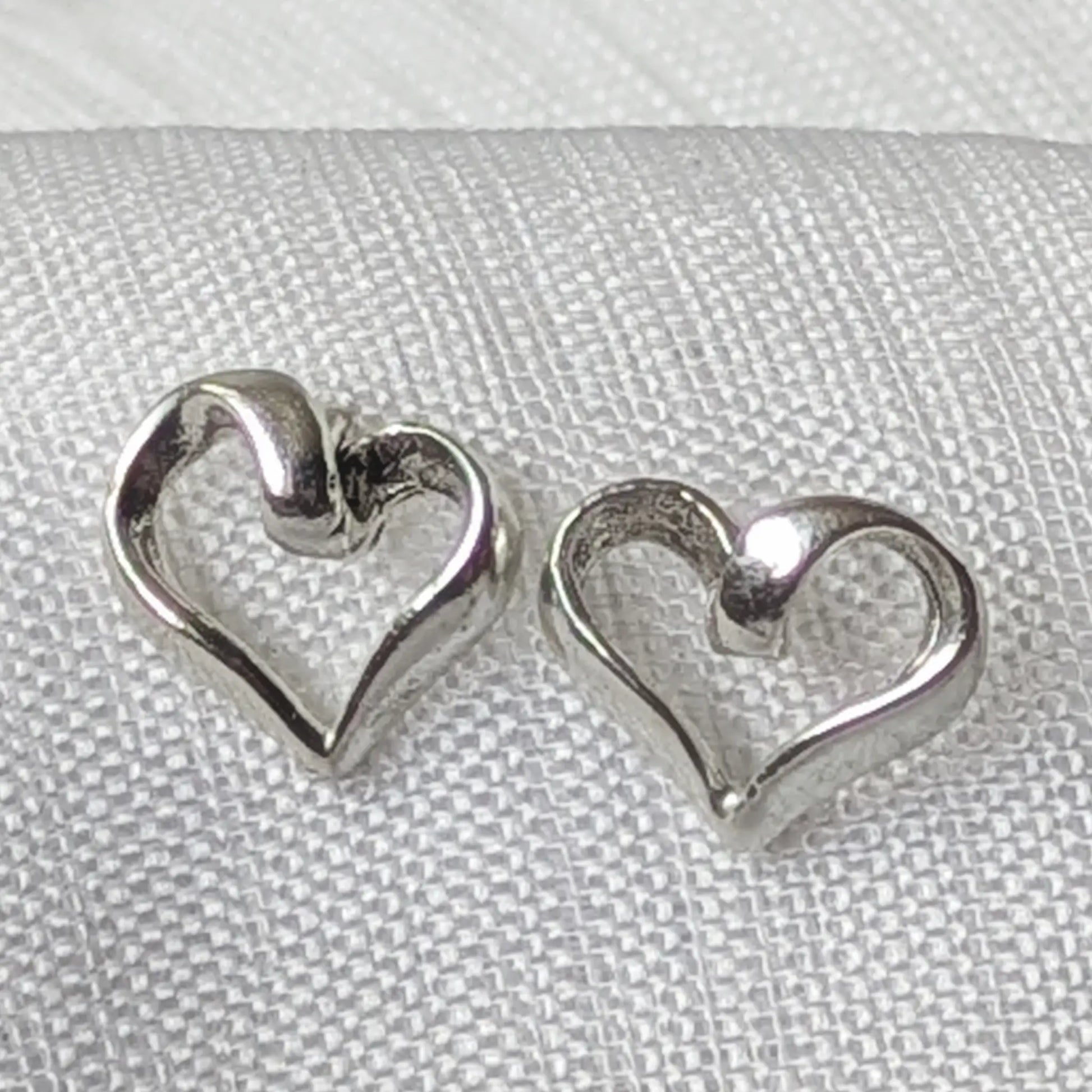 Nahaufnahme der geschwungenen Herz Ohrstecker aus hochglanzpoliertem 925 Sterling Silber