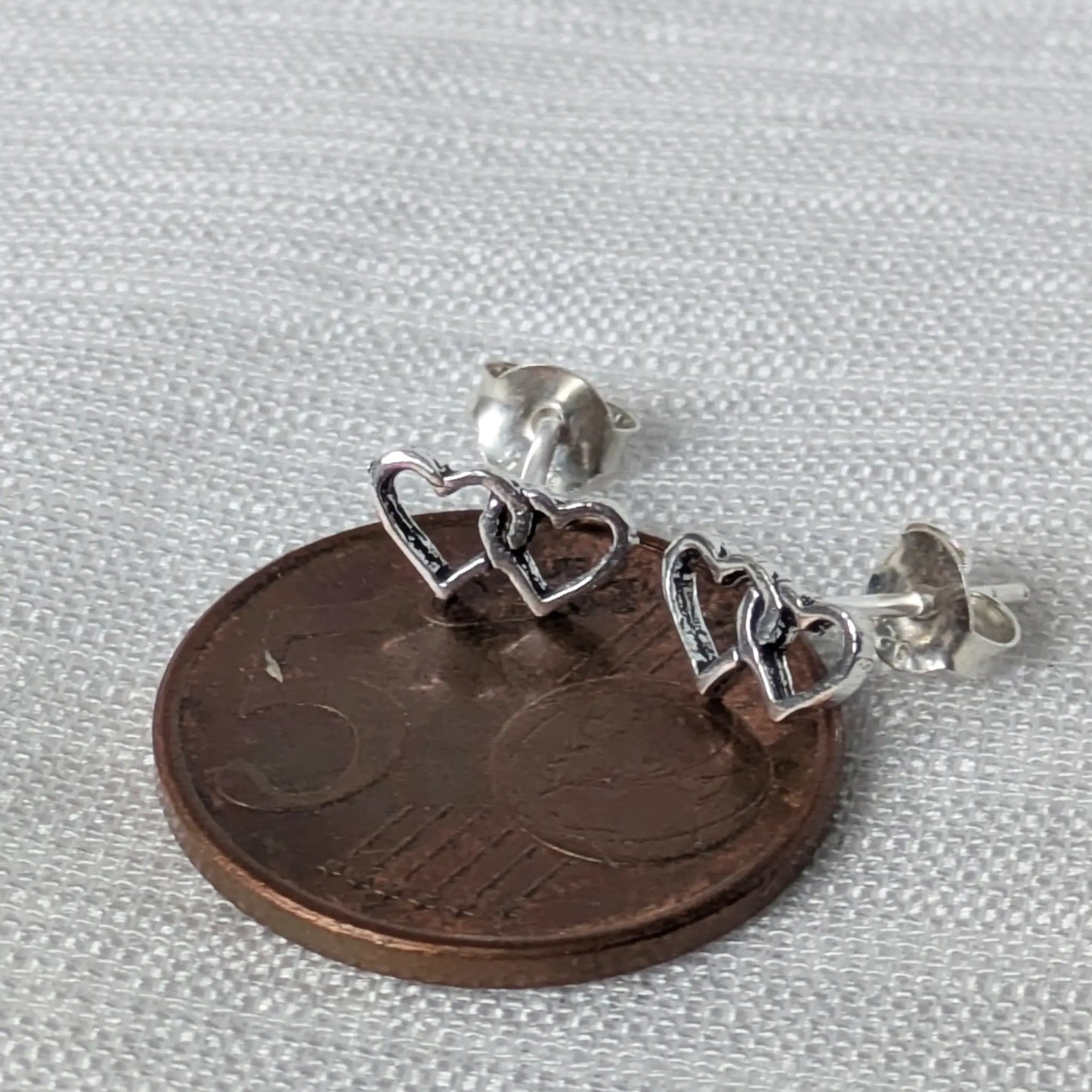 Größenvergleich der Herz-Ohrstecker auf einer 5-Cent-Münze.