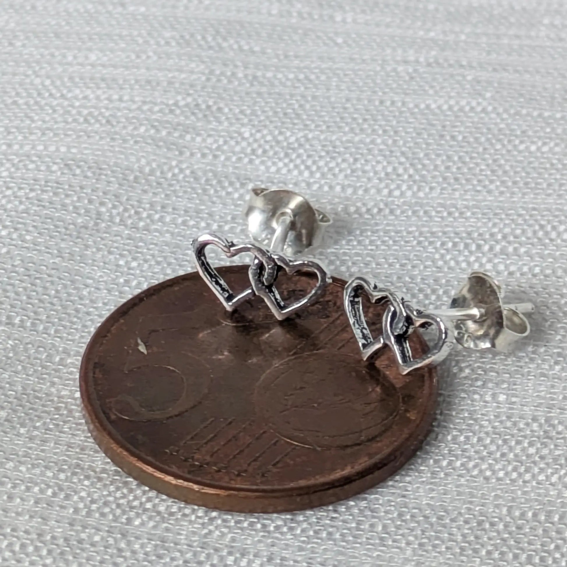 Größenvergleich der Herz-Ohrstecker auf einer 5-Cent-Münze.
