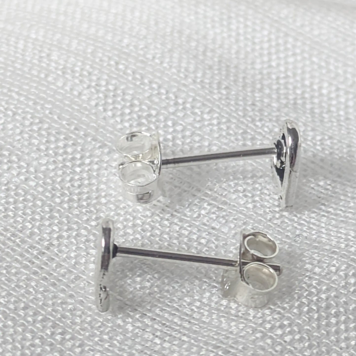 Seitenansicht der silbernen Herz-Ohrstecker zur Darstellung der feinen Verarbeitung und der stabilen Stiftführung aus 925 Silber.