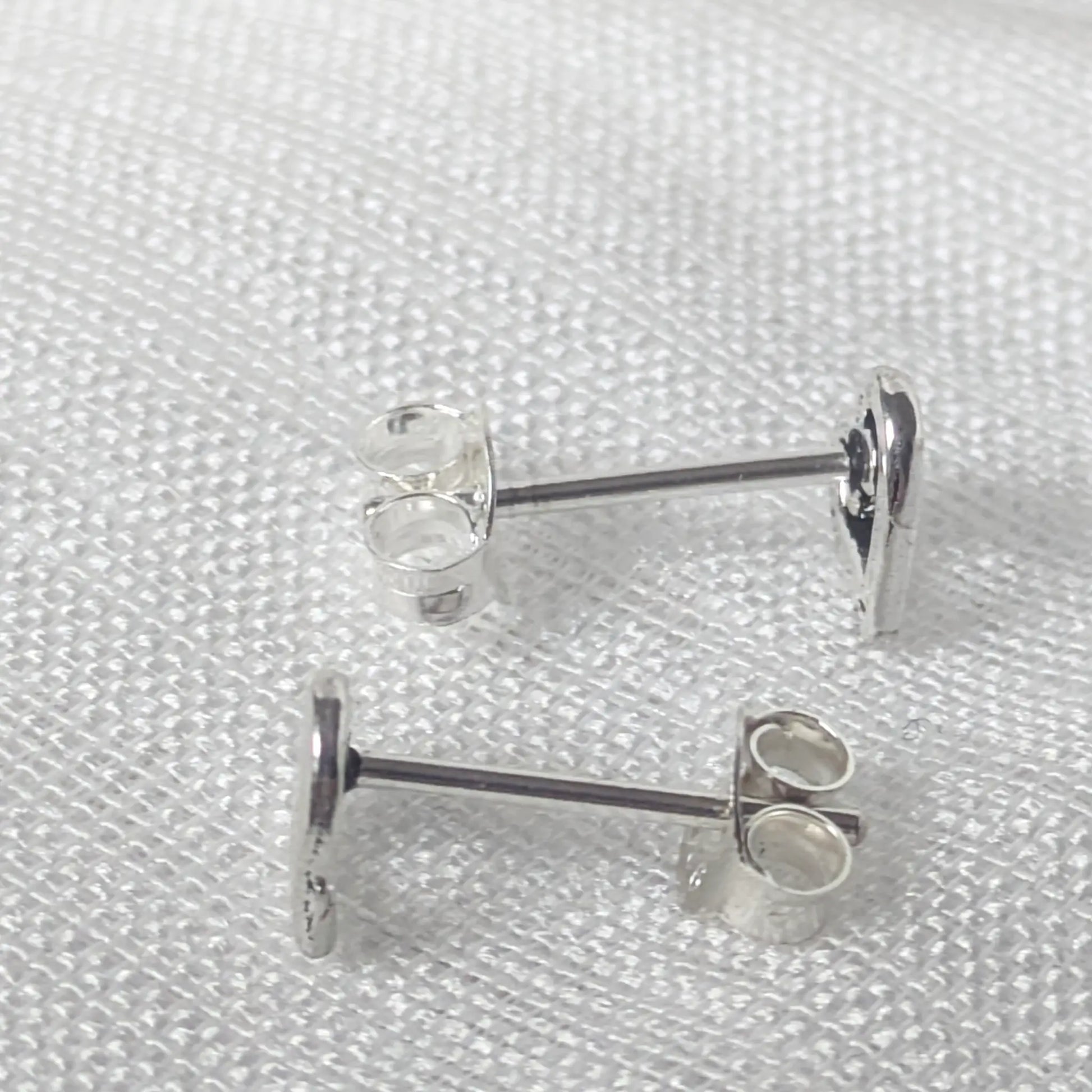 Seitenansicht der silbernen Herz-Ohrstecker zur Darstellung der feinen Verarbeitung und der stabilen Stiftführung aus 925 Silber.