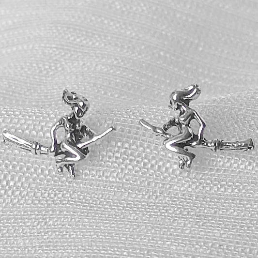 Nahaufnahme von zwei filigranen Hexen-Ohrsteckern aus glänzendem 925 Sterling Silber mit sichtbaren Details.