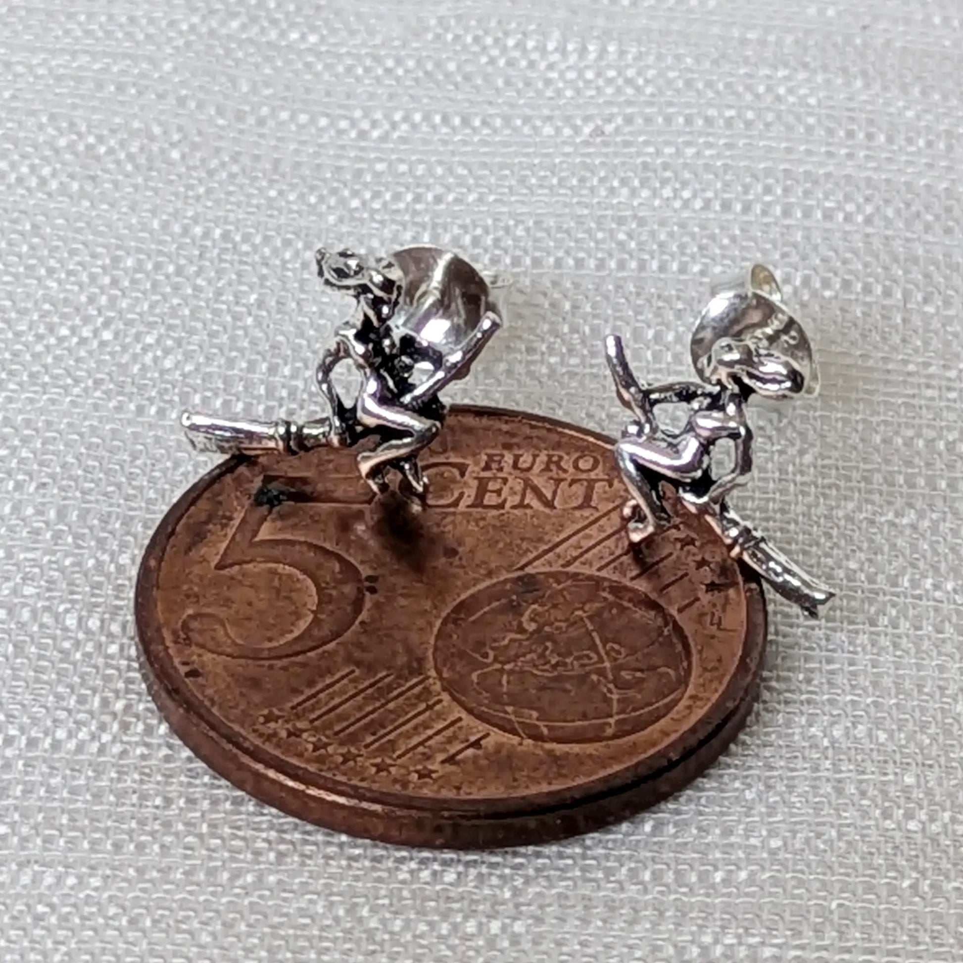 Größenvergleich der kleinen Hexen-Ohrringe aus Silber auf einer 5-Cent-Münze zur Veranschaulichung der Maße.