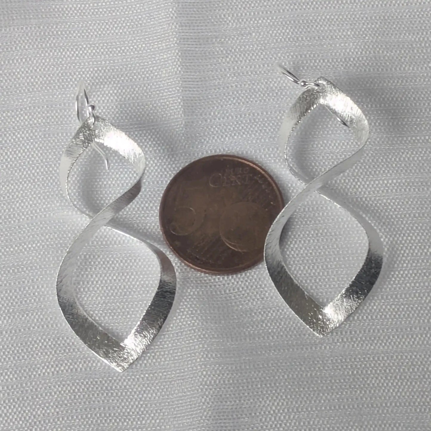 Größenvergleich 925 Silber Infinity Ohrhänger neben 5-Cent Münze.