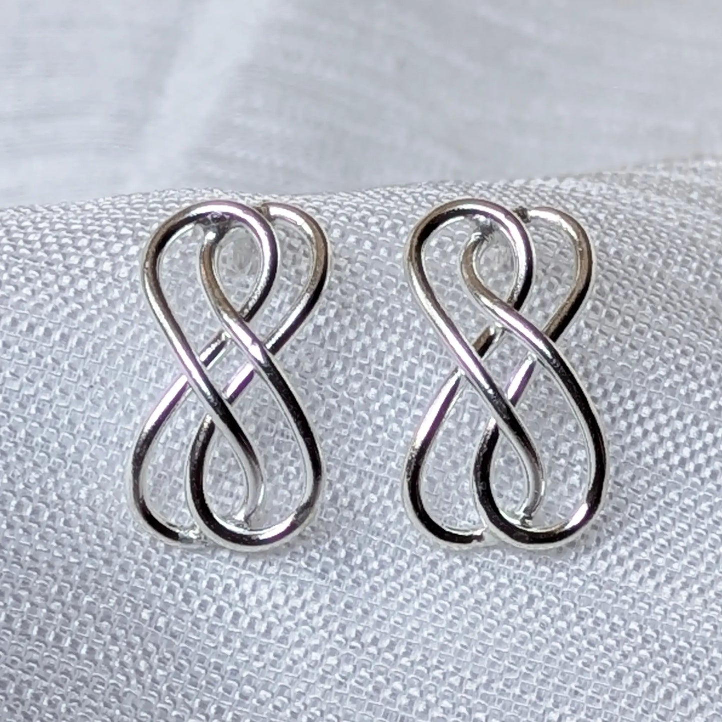 Nahaufnahme Infinity Ohrstecker aus 925 Sterling Silber mit doppelter Unendlichkeitsschleife