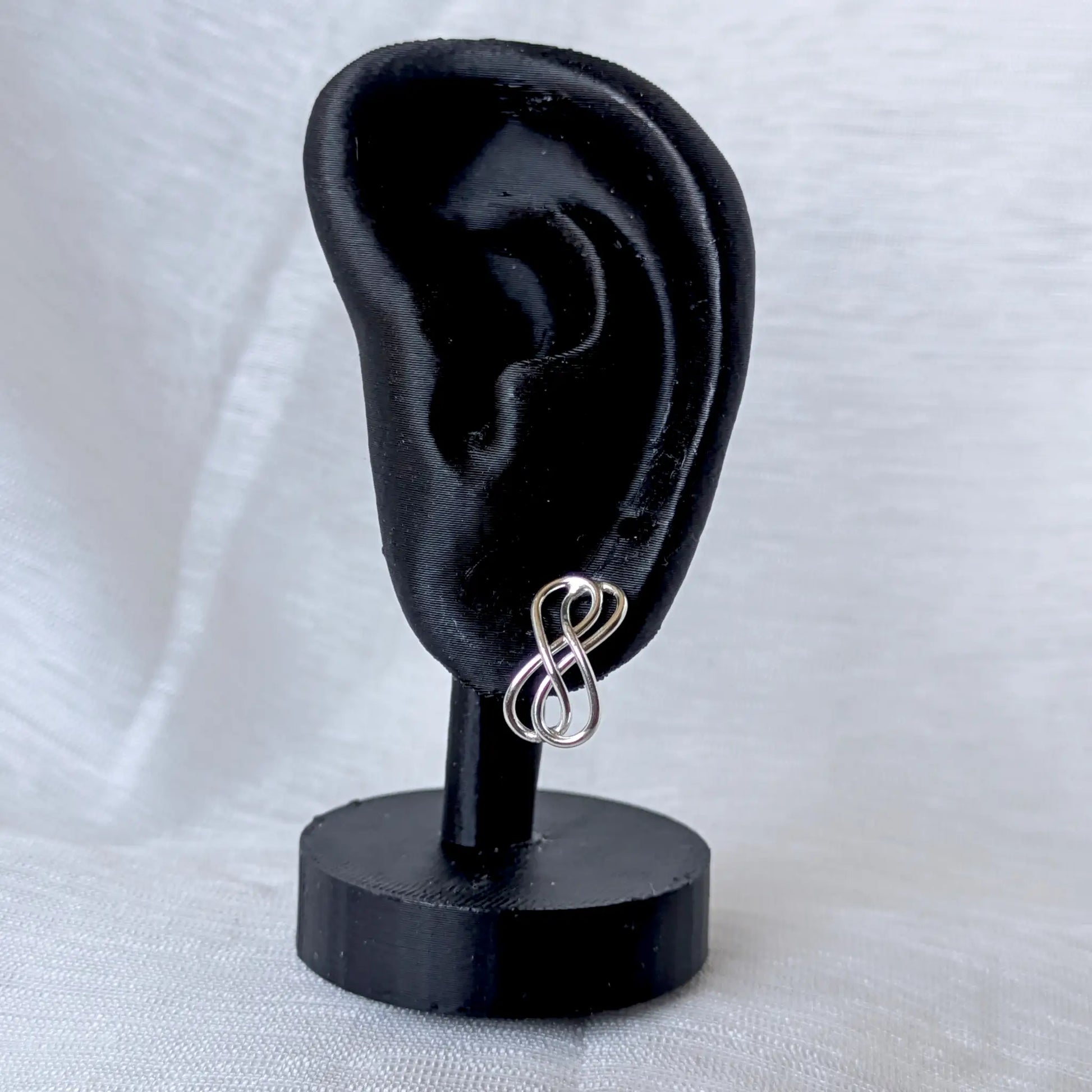 Filigrane Infinity Ohrstecker 925 Silber getragen am schwarzen Ohr-Display zur Größenansicht