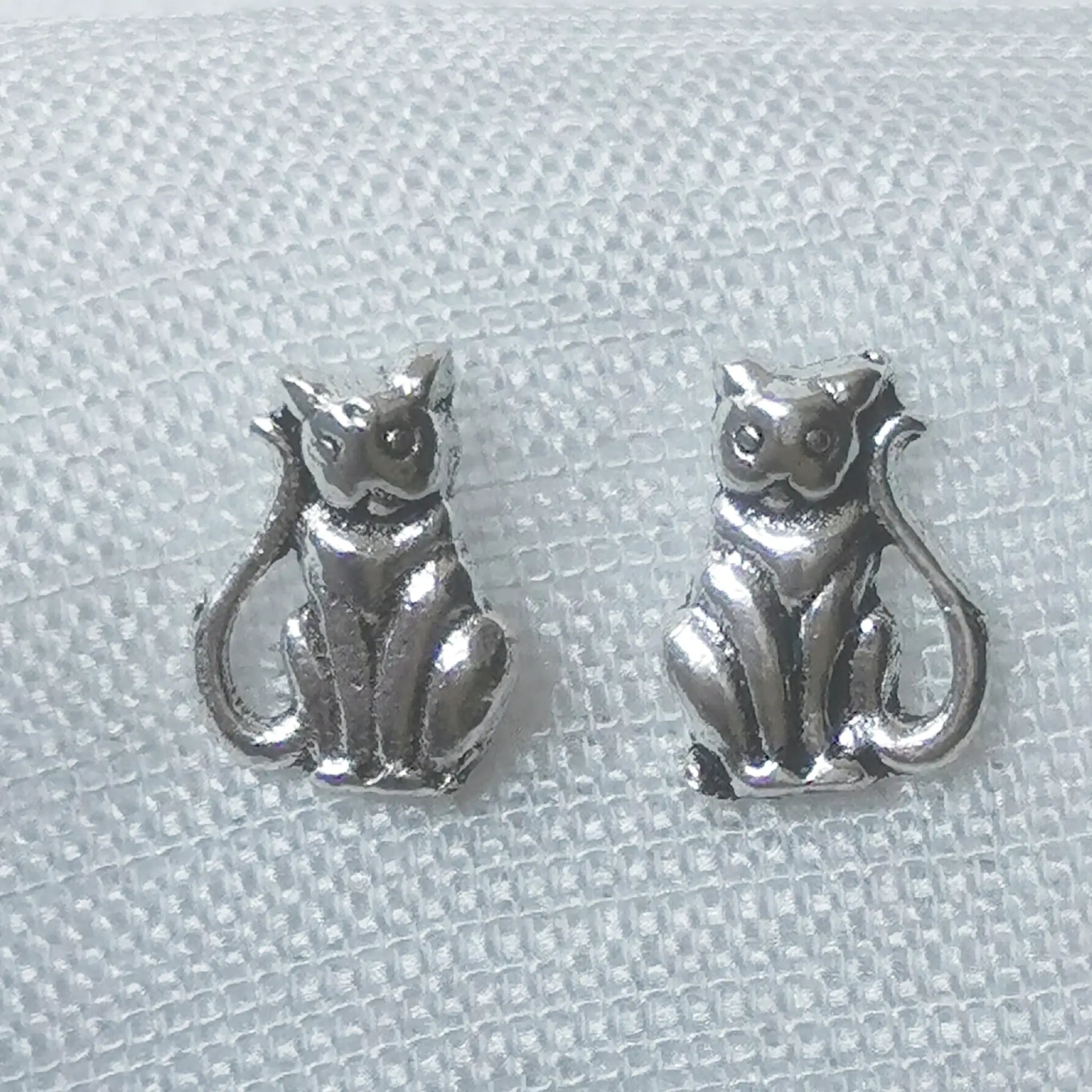 Nahaufnahme von zwei detaillierten Katzen-Ohrsteckern aus 925 Sterling Silber mit antikem Finish im Vintage-Stil.