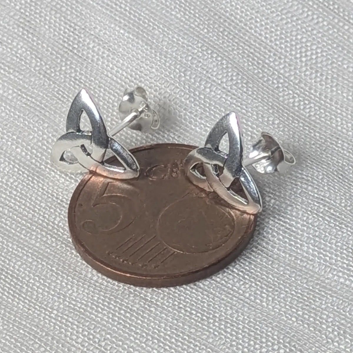 Größenvergleich: Polierte Triquetra Silberohrstecker liegend auf einer 5-Cent-Münze.