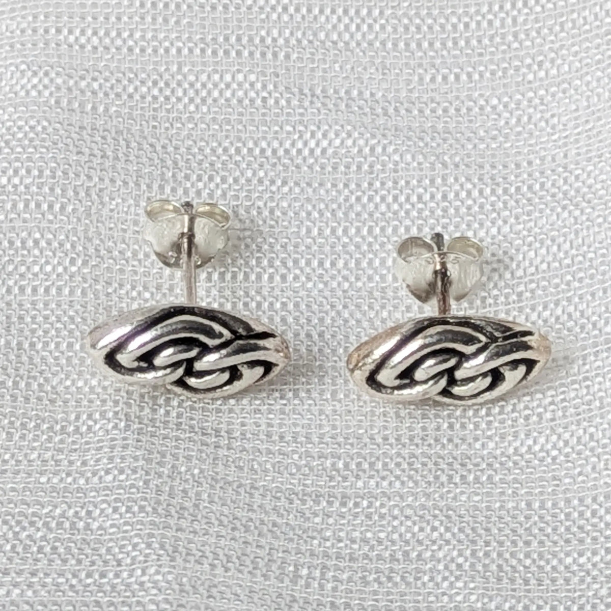 Frontalansicht detailreicher Silberohrstecker im geflochtenen Vintage-Design