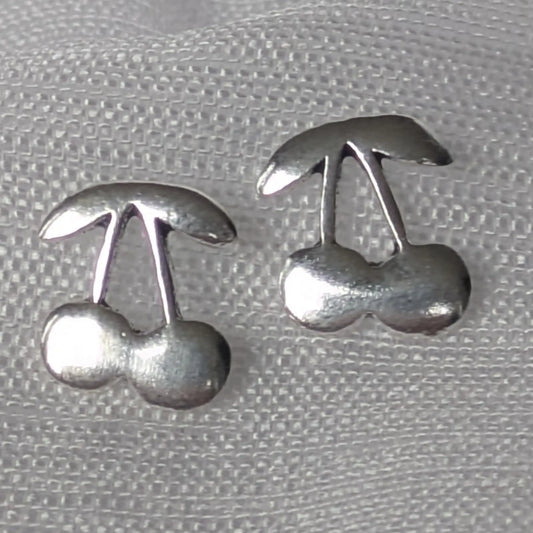 Detaillierte Nahaufnahme von Kirsch-Ohrsteckern aus glänzendem 925 Sterling Silber mit feiner Oberflächenstruktur.