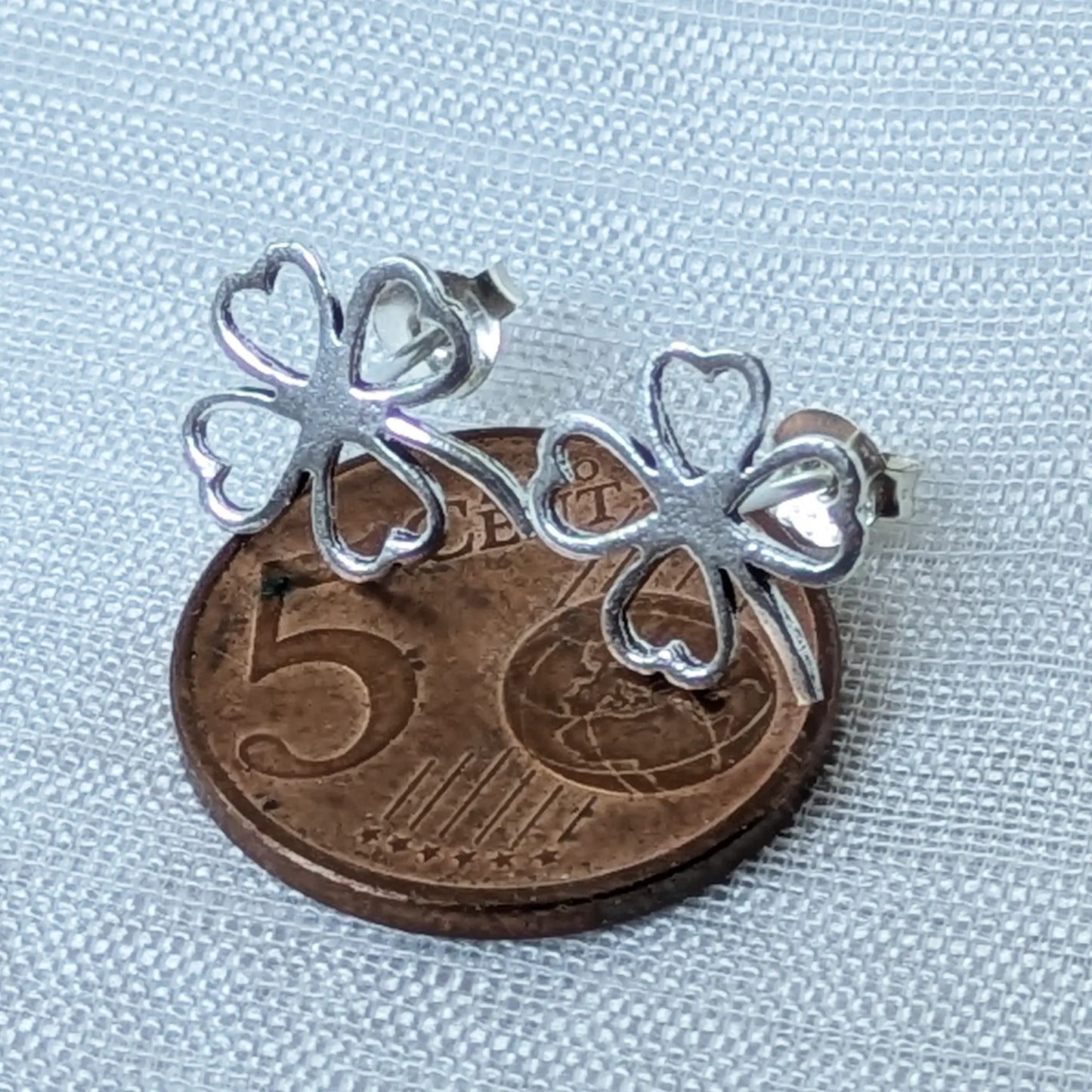 Kleeblatt Ohrstecker aus 925 Silber im Größenvergleich auf einer 5-Cent-Münze