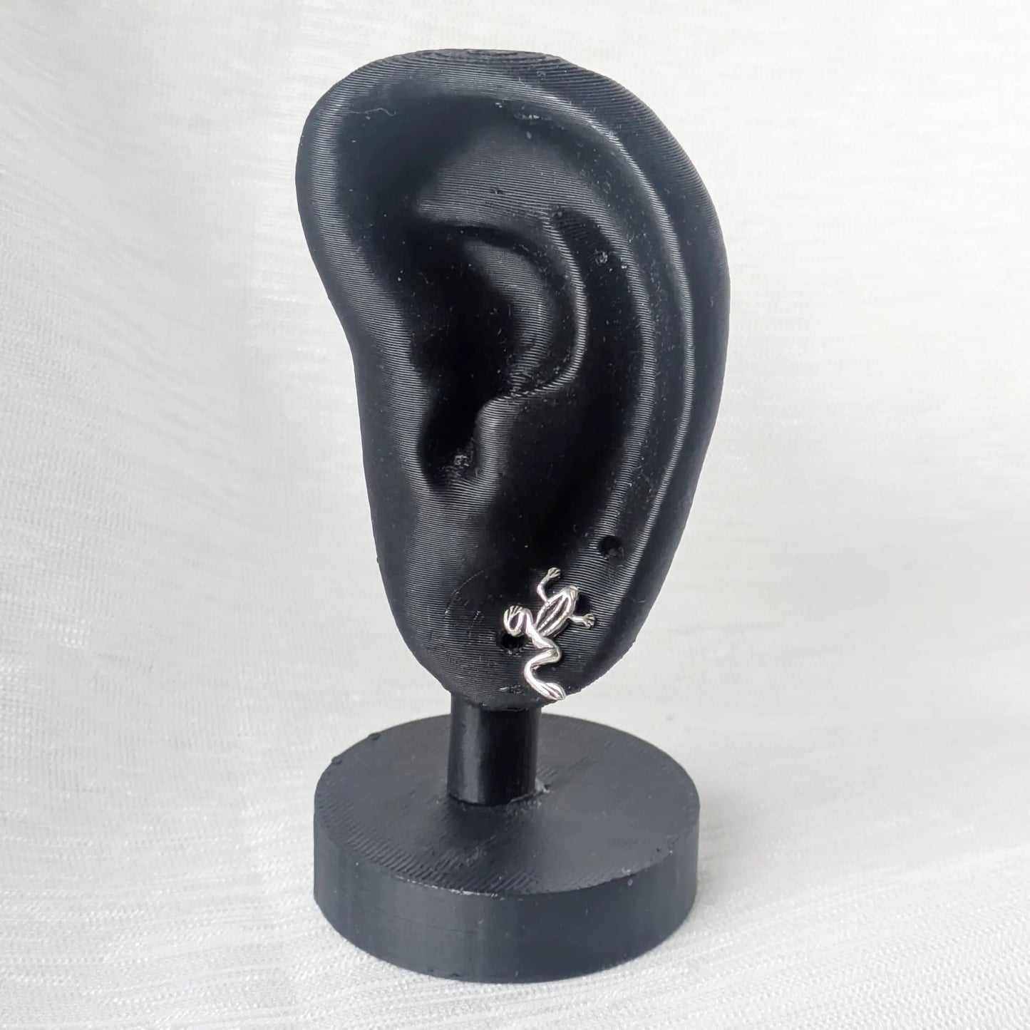 Kleine Frosch Ohrstecker Silber präsentiert am schwarzen Ohr-Display