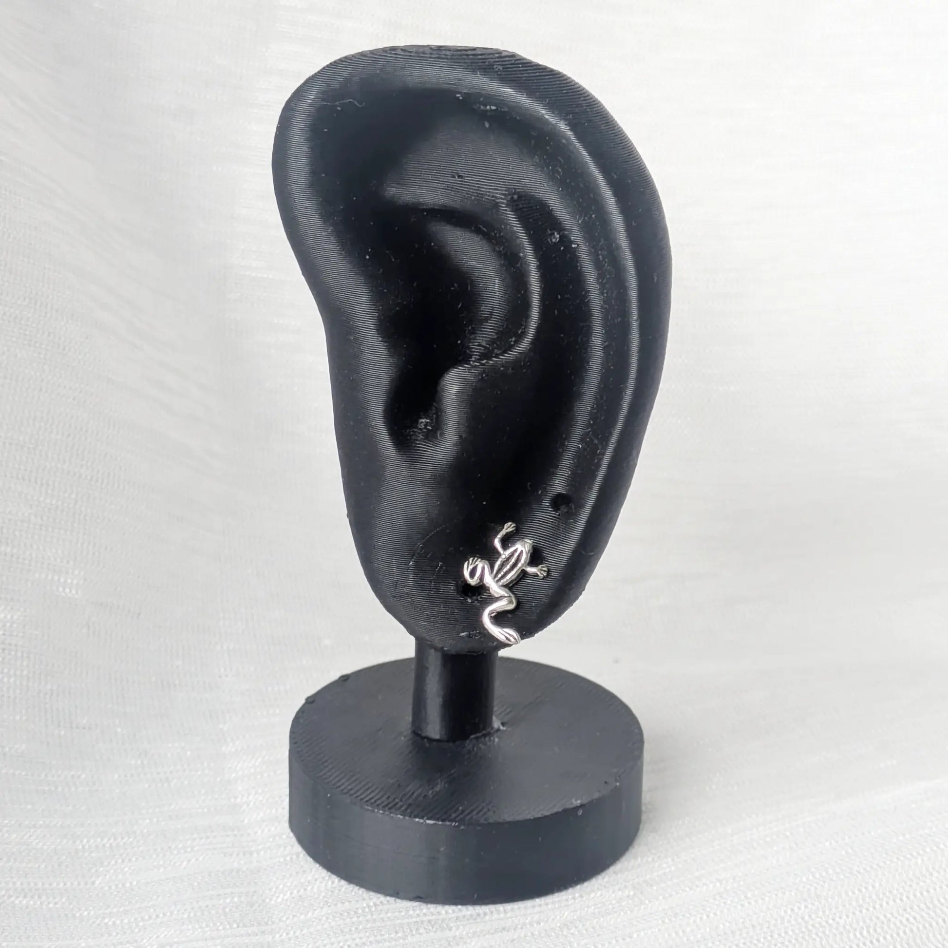 Kleine Frosch Ohrstecker Silber präsentiert am schwarzen Ohr-Display