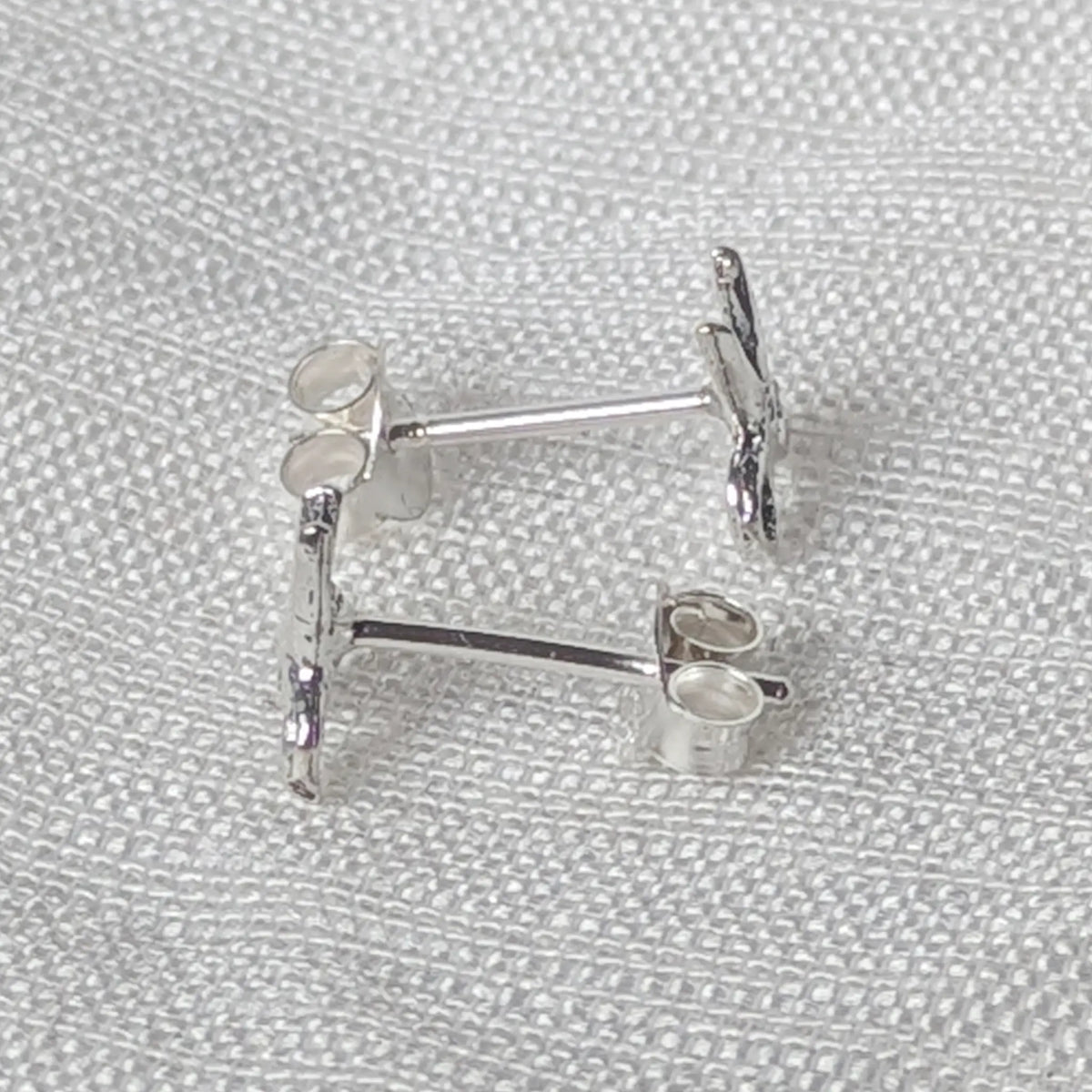 Seitenansicht der silbernen Scheren-Ohrstecker mit robustem, angelötetem Stift für einen sicheren Halt im Ohr.