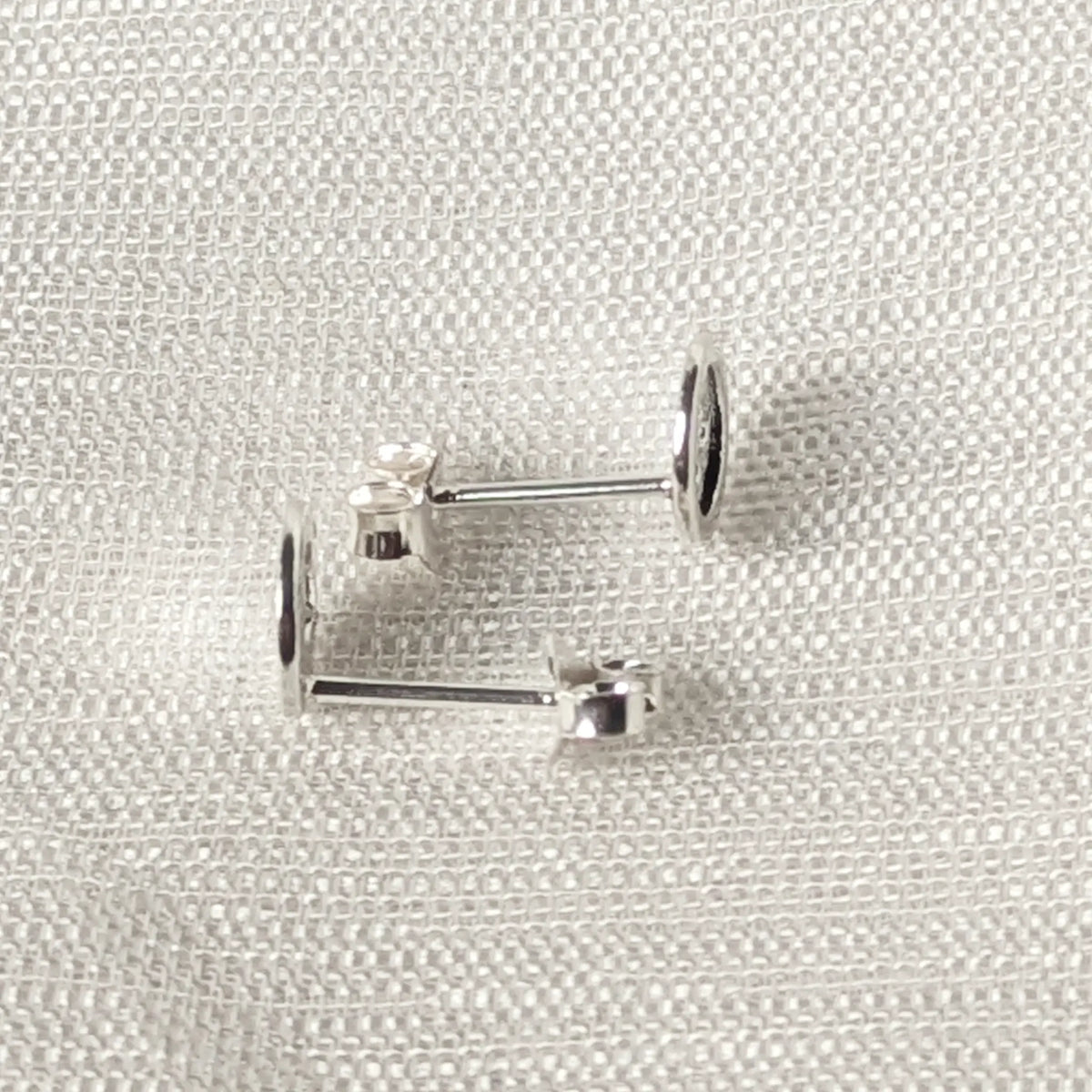 Seitliche Perspektive der flachen Knopf-Ohrstecker aus echtem 925 Sterling Silber.