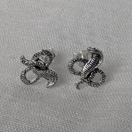 Elegante Kobra Schlangenstecker aus Sterling Silber auf weißem Stoffhintergrund.