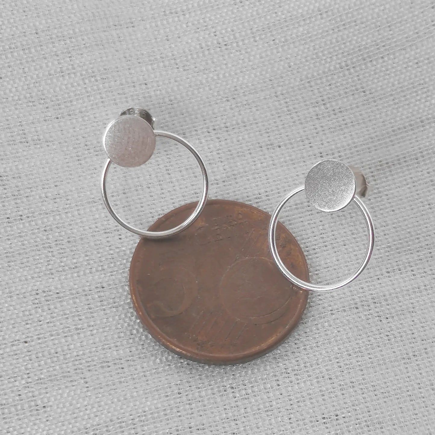 Größenvergleich der minimalistischen Kreis-Ohrringe platziert auf einer 5-Cent-Münze zur exakten Einschätzung der Maße.