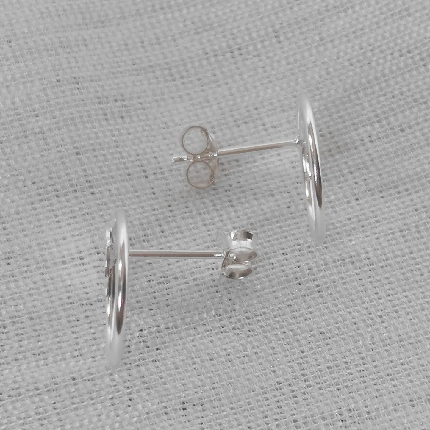 Seitenansicht der flachen Silber-Ohrstecker zur Verdeutlichung des Steckverschlusses und der präzisen Verarbeitung.