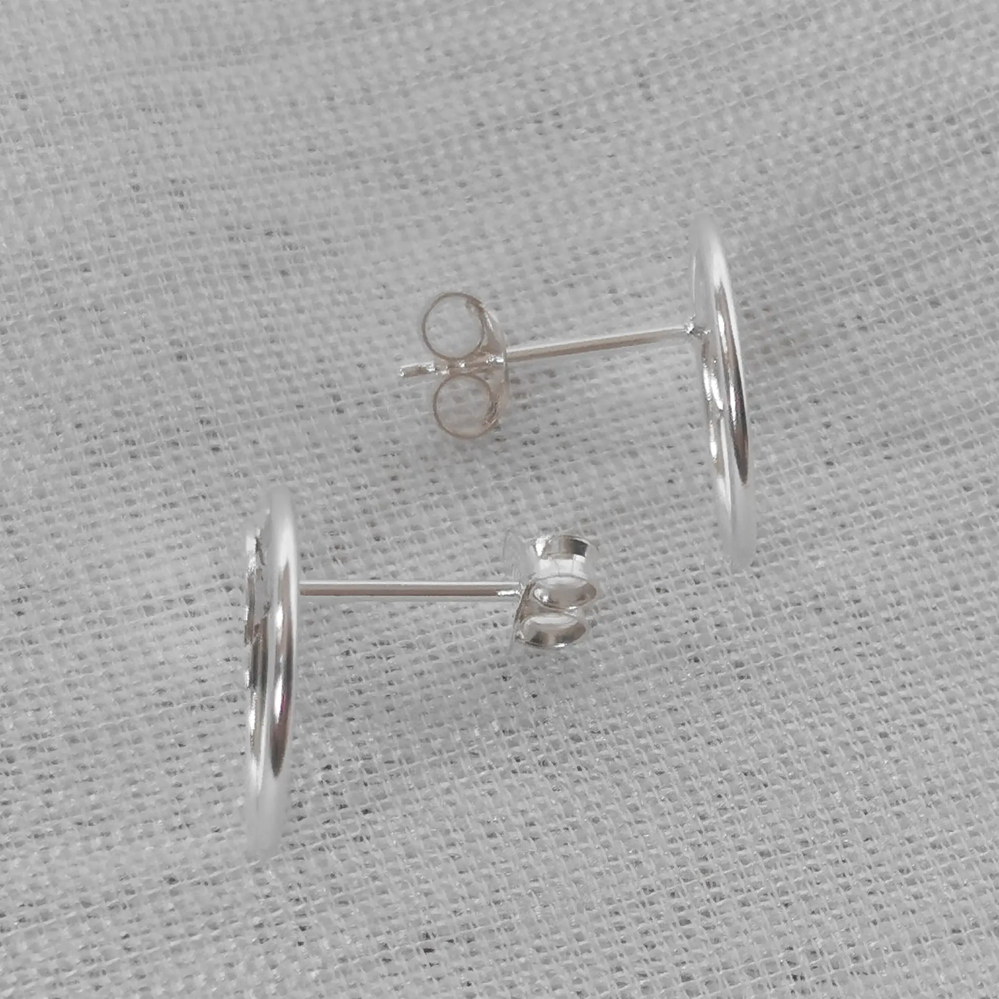 Seitenansicht der flachen Silber-Ohrstecker zur Verdeutlichung des Steckverschlusses und der präzisen Verarbeitung.