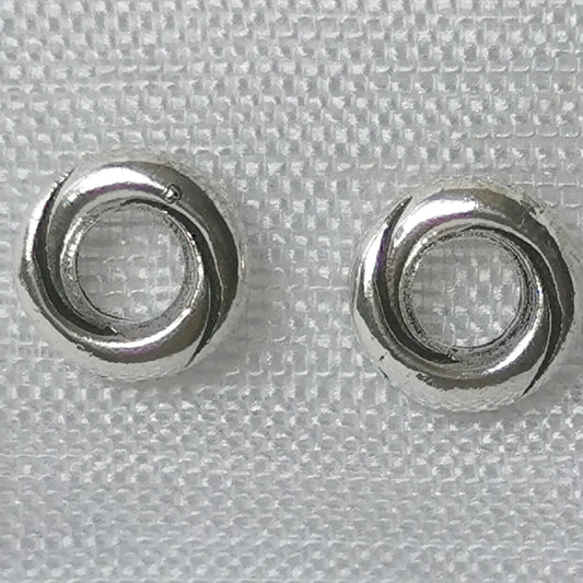 Detailaufnahme von runden 925 Silber Ohrsteckern in gedrehter Kordel-Optik auf weißem Stoffhintergrund.