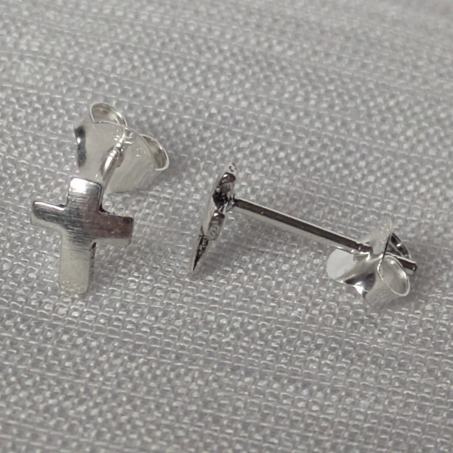 Seitenansicht der silbernen Kreuz-Stecker zur Veranschaulichung der Tiefe.
