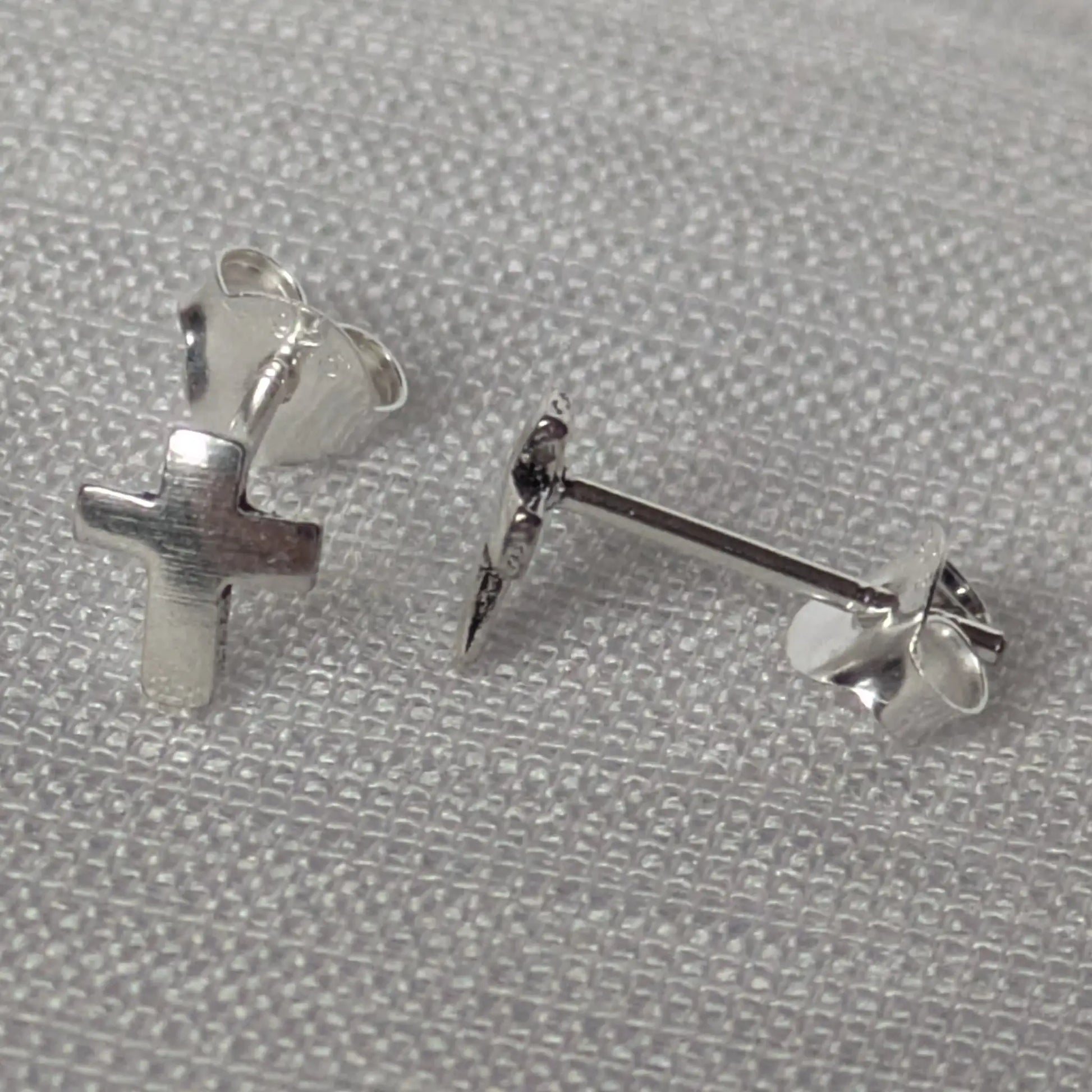 Seitenansicht der silbernen Kreuz-Stecker zur Veranschaulichung der Tiefe.