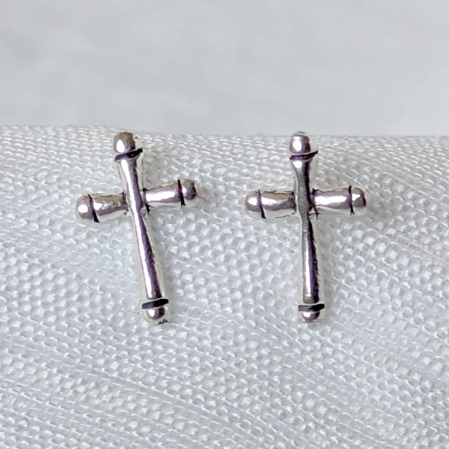 Nahaufnahme der filigranen 925 Silber Kreuz Ohrstecker mit feinen oxidierten Details.