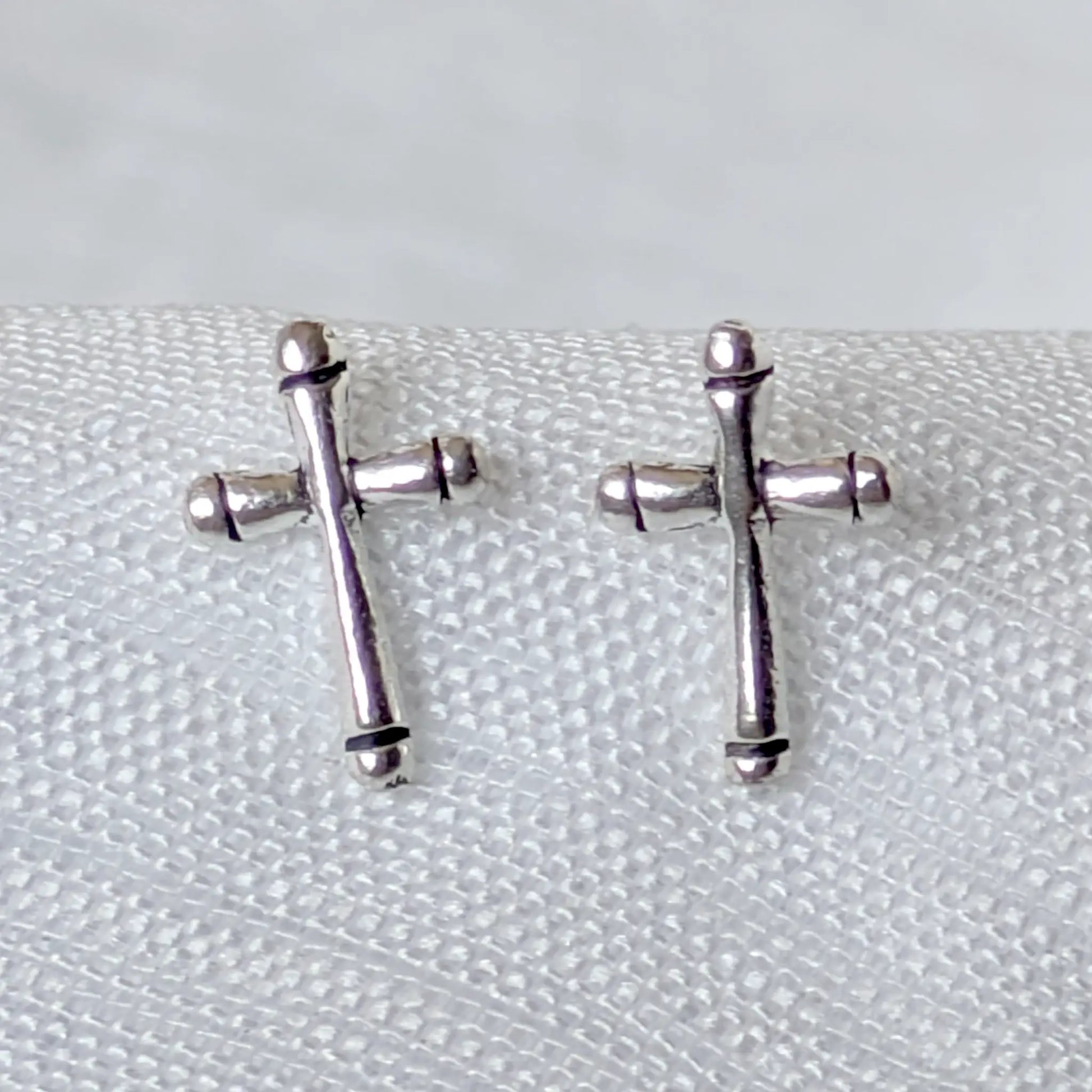 Nahaufnahme der filigranen 925 Silber Kreuz Ohrstecker mit feinen oxidierten Details.