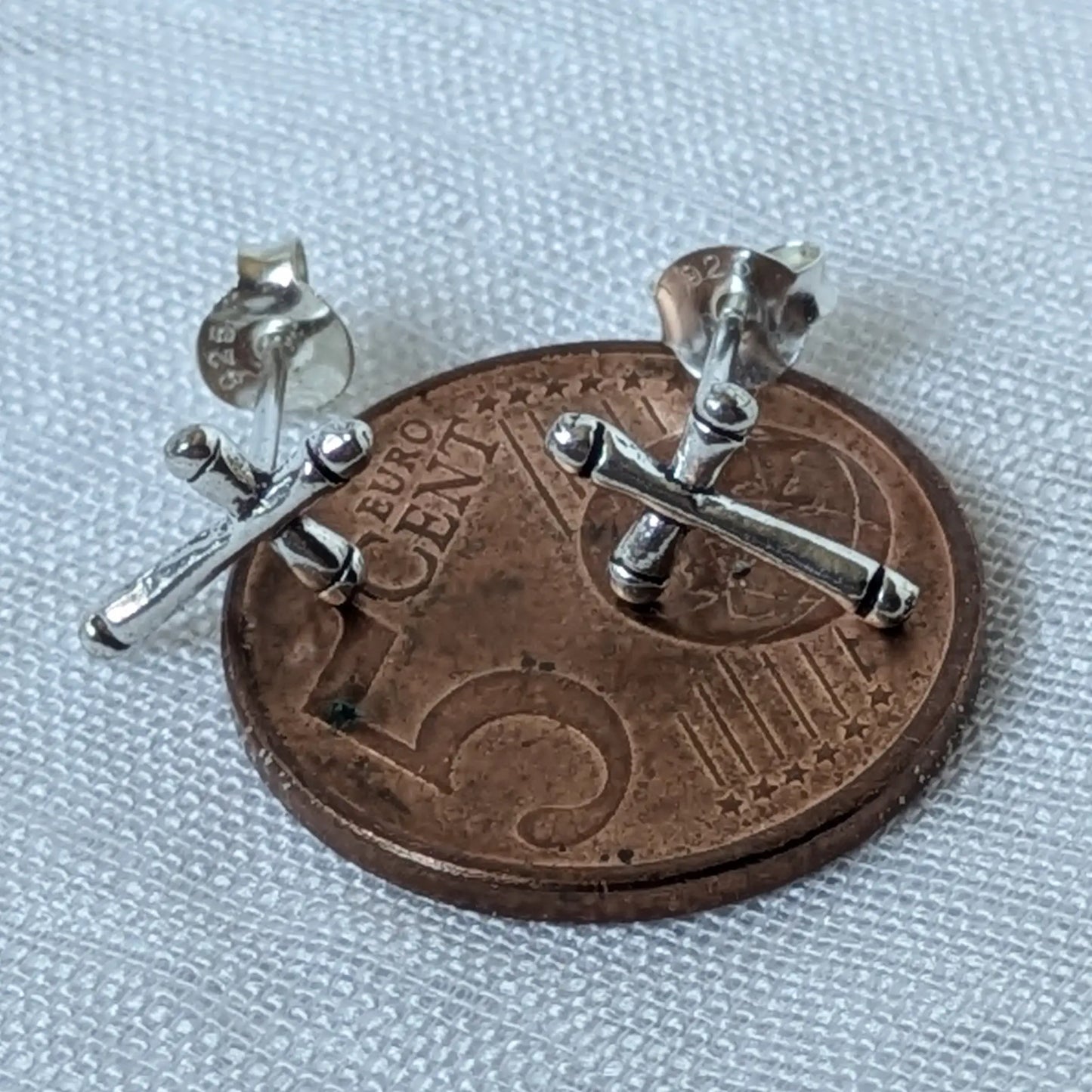 Größenvergleich der filigranen 925 Silber Kreuz Ohrstecker auf einer 5-Cent-Münze.