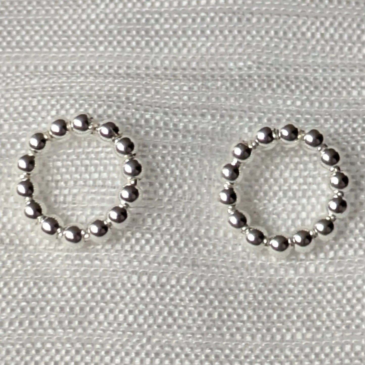 Nahaufnahme der kugeligen Oberflächenstruktur der silbernen Kreis-Ohrstecker.