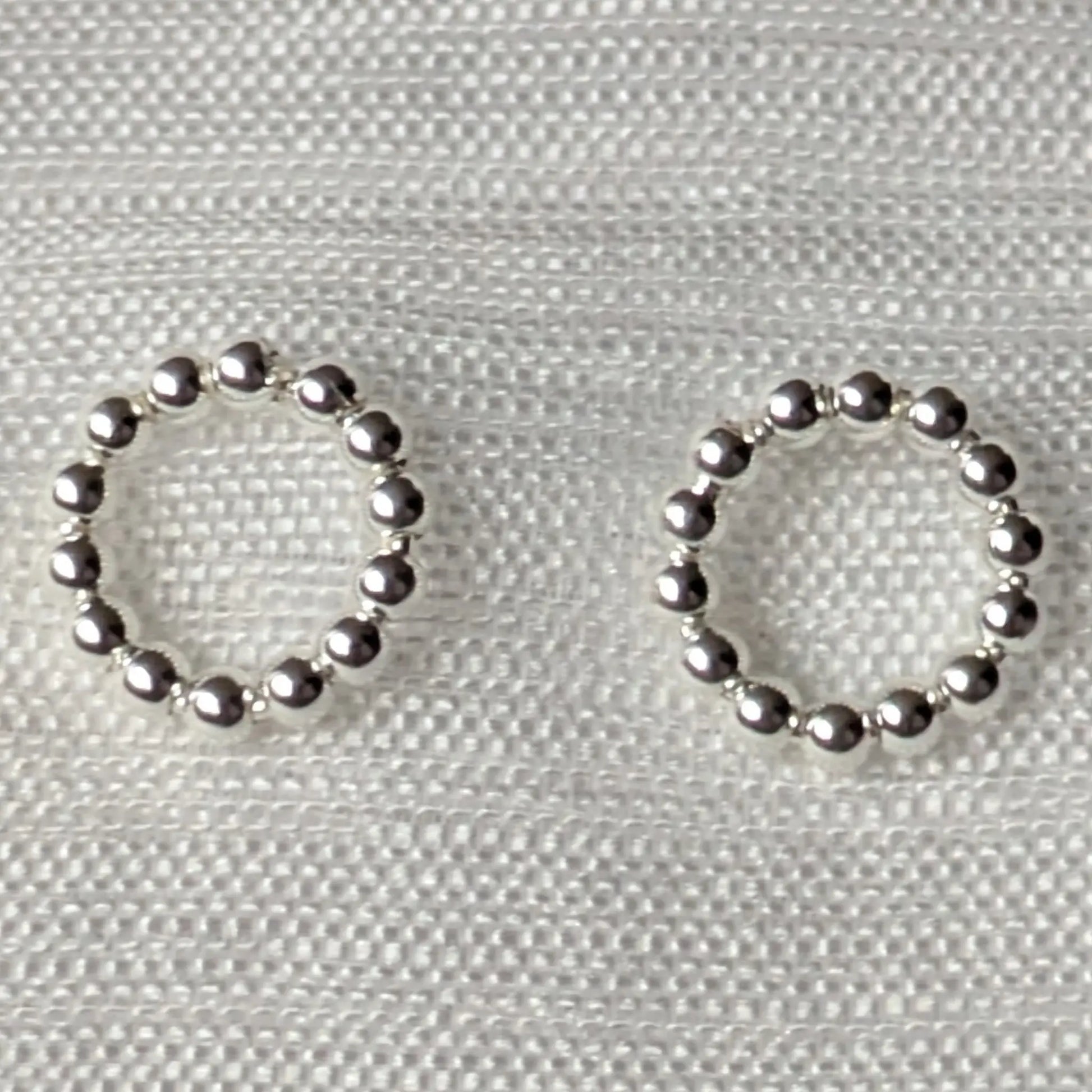 Nahaufnahme der kugeligen Oberflächenstruktur der silbernen Kreis-Ohrstecker.