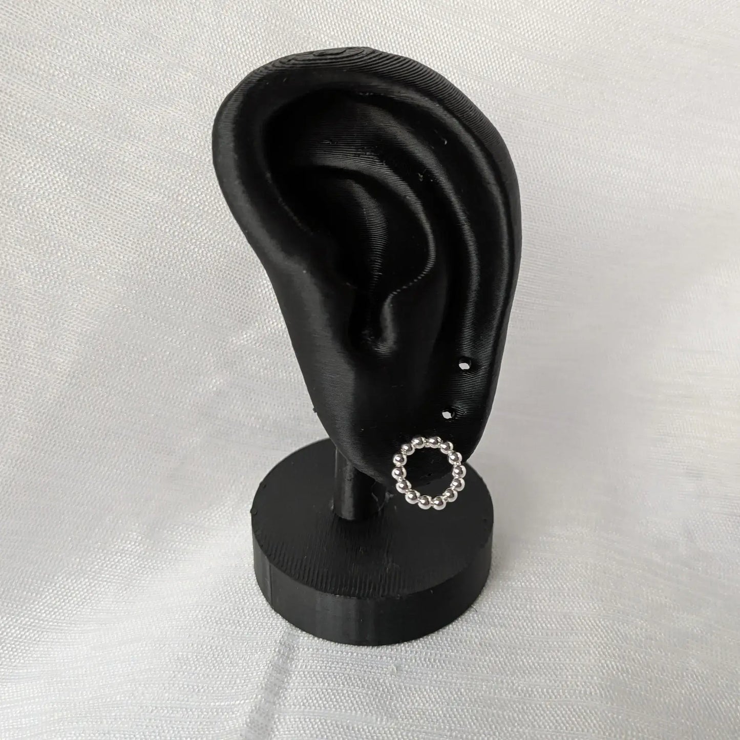Kugel-Kreis Ohrstecker aus Silber elegant präsentiert an einem schwarzen Ohr-Display.