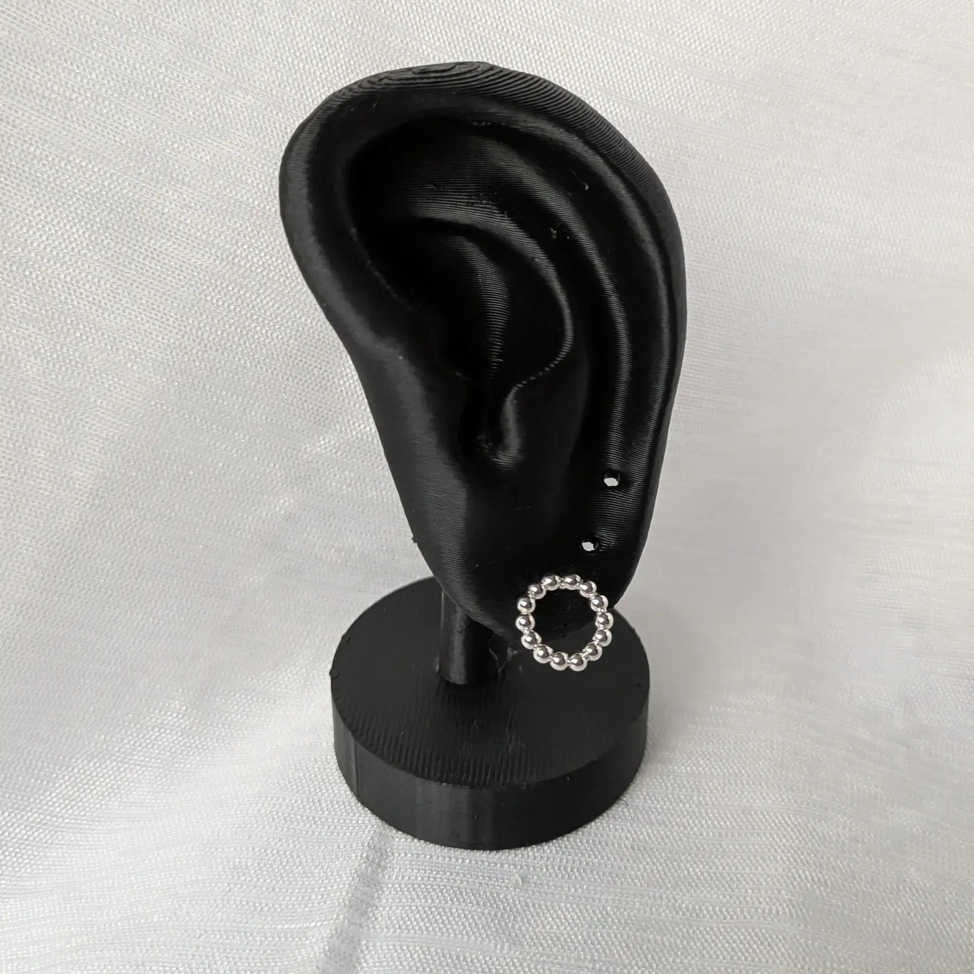 Kugel-Kreis Ohrstecker aus Silber elegant präsentiert an einem schwarzen Ohr-Display.
