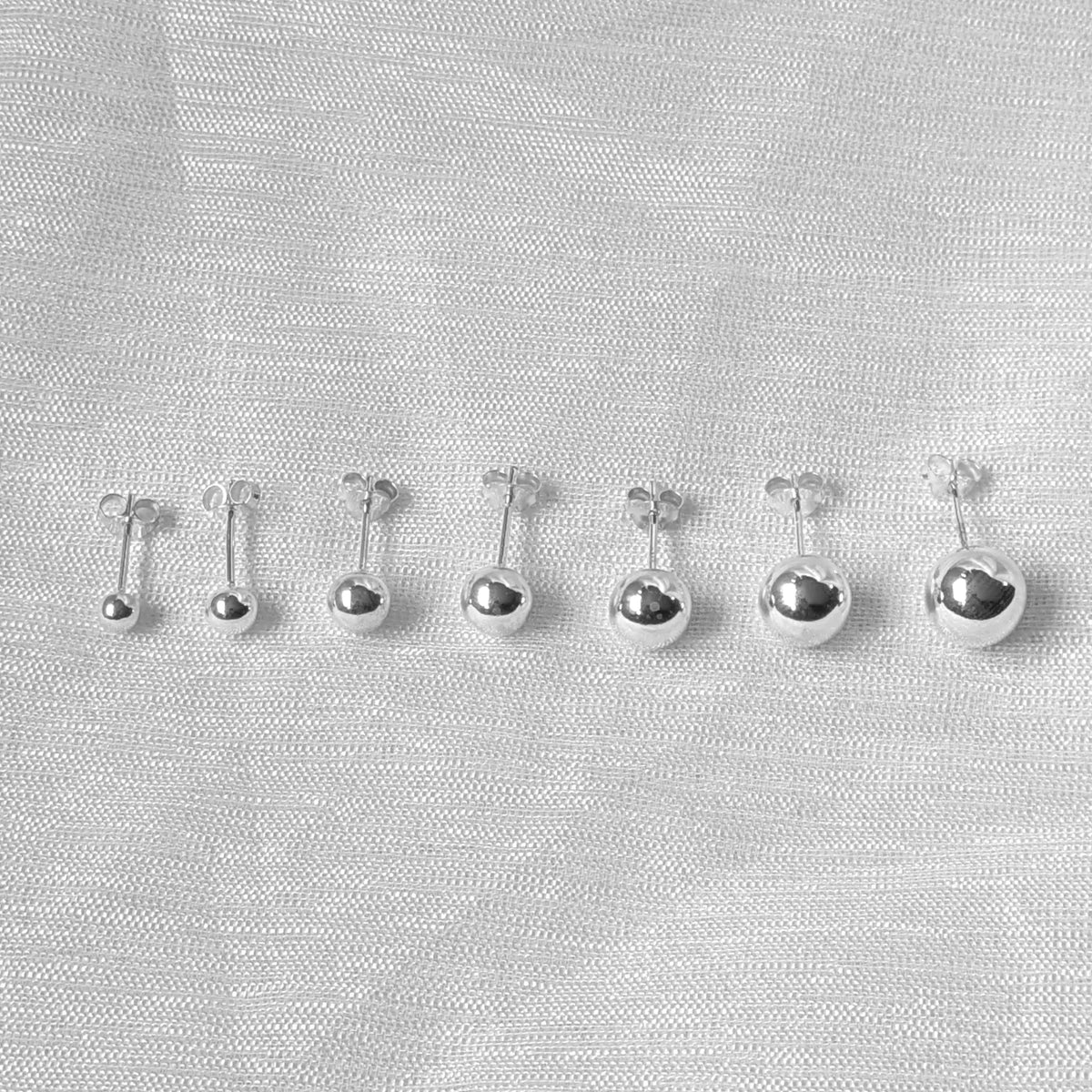 Frontalansicht der runden, schlichten Silberohrstecker mit perfekt glatter, reflektierender Oberfläche 4mm bis 10mm.