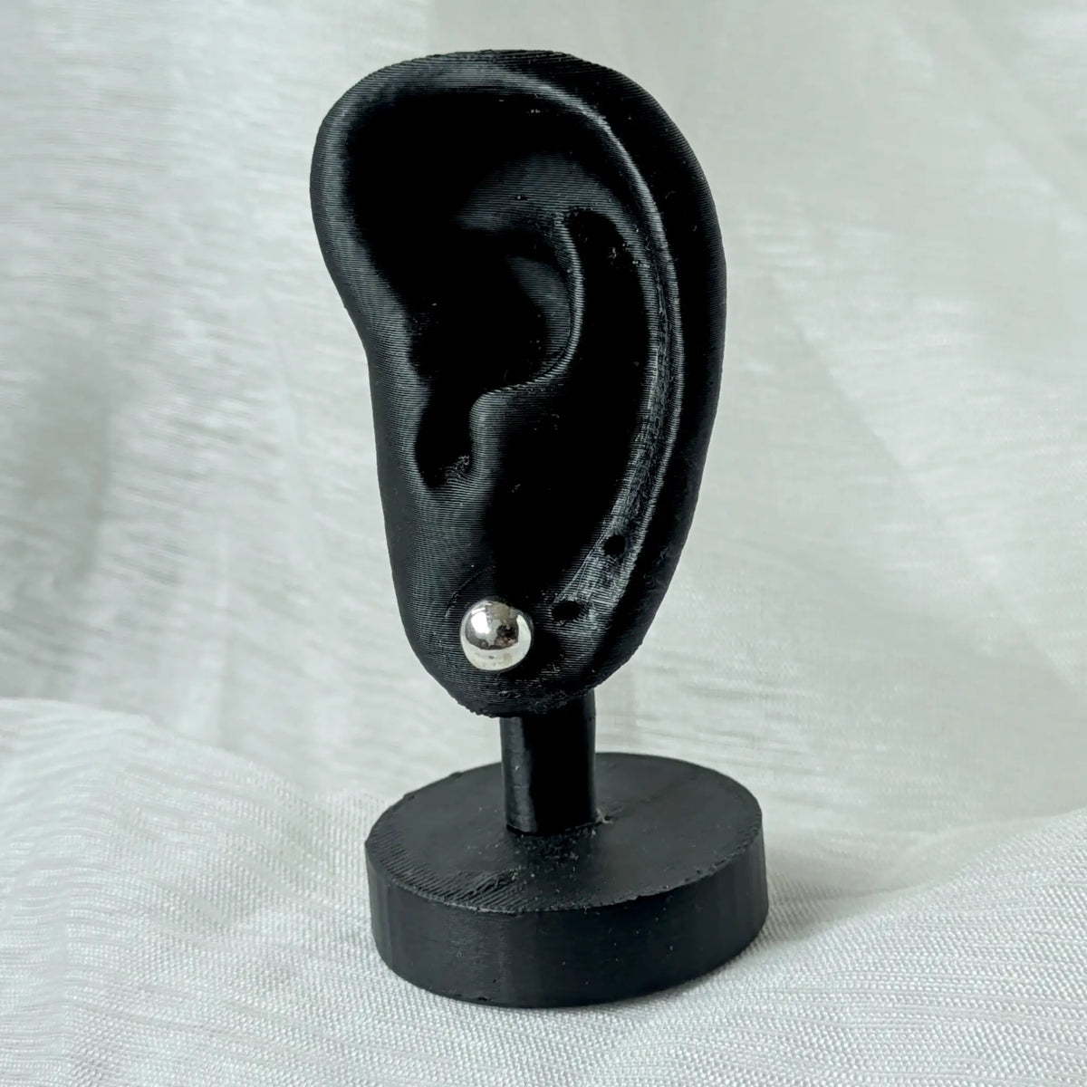 Ein 8mm großer Silber-Kugelohrstecker, dezent und elegant an einem schwarzen 3D-Ohr-Display präsentiert.
