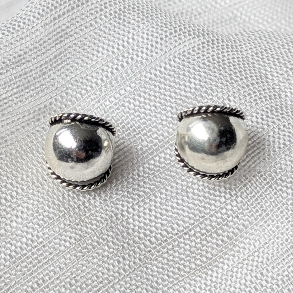 Nahaufnahme von 925 Silber Kugel-Ohrsteckern mit oxidiertem Kordel-Detail.
