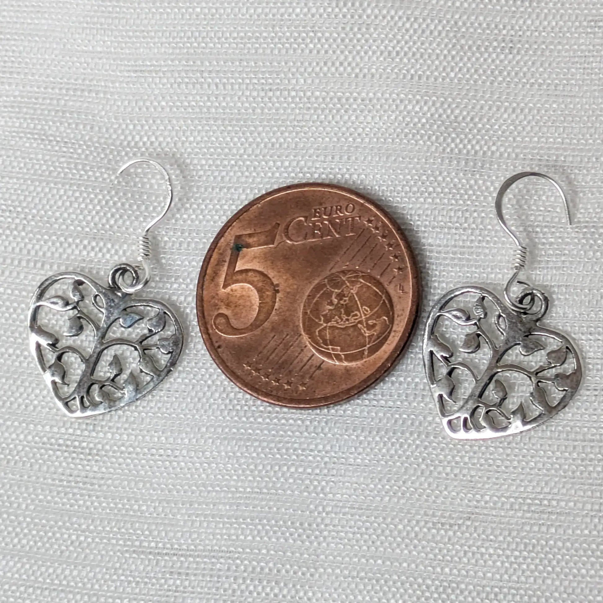 Größenvergleich der herzförmigen 925 Silberohrringe platziert neben einer 5-Cent-Münze zur exakten Dimensionsdarstellung.