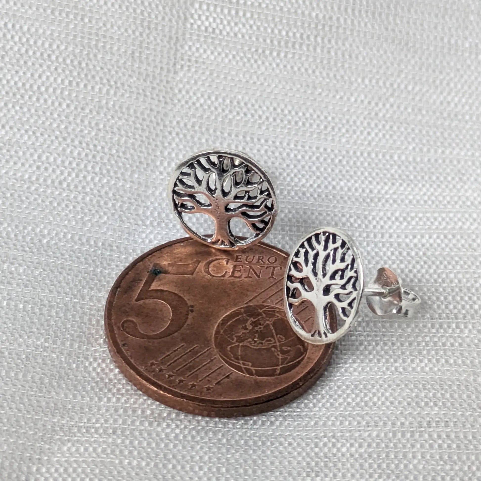 Größenvergleich der filigranen Tree of Life Silberohrstecker flach neben einer 5-Cent-Münze zur Veranschaulichung des Durchmessers.