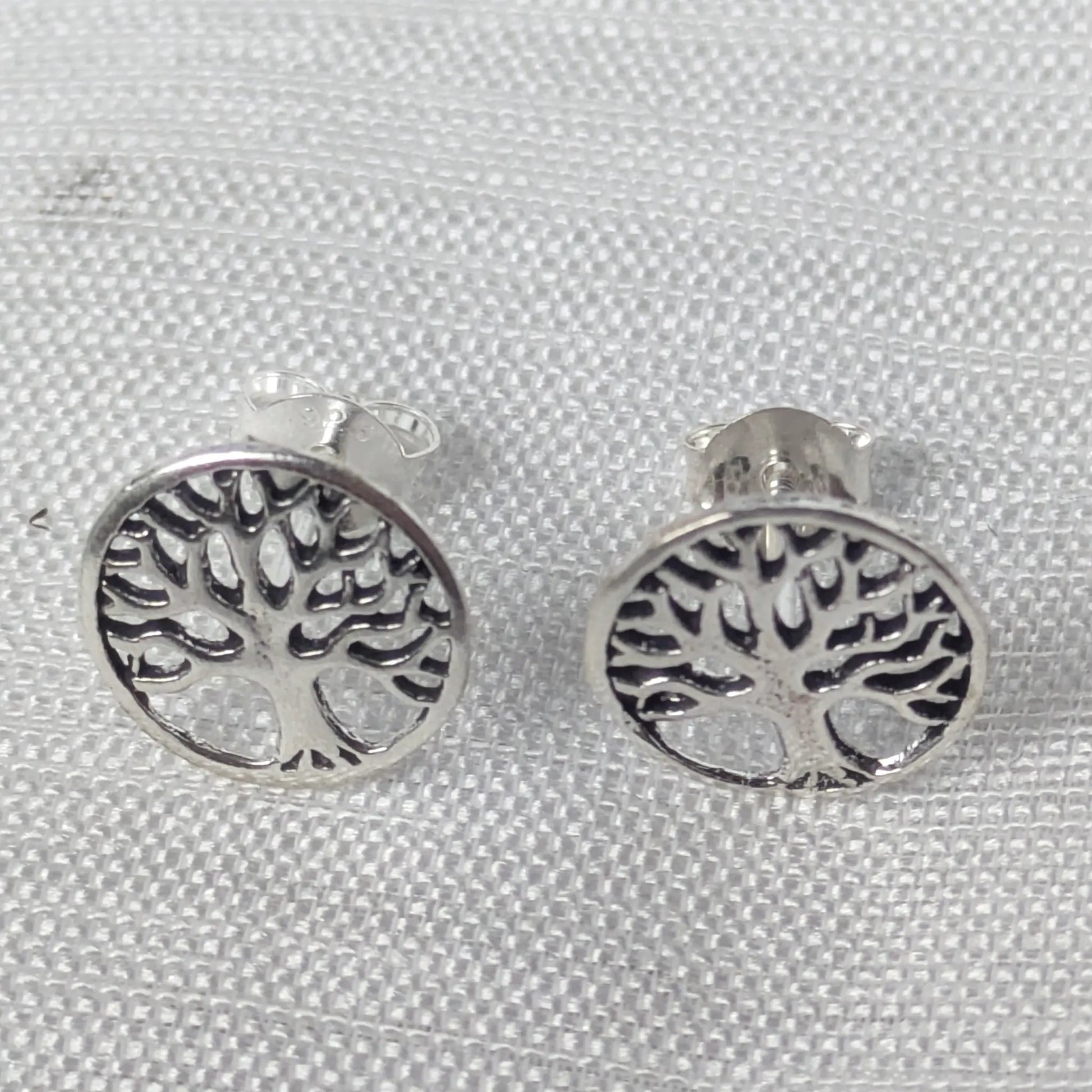 Frontale Ansicht der Tree of Life Ohrringe aus Sterling Silber mit kontrastierenden, dunkel patinierten Zwischenräumen.