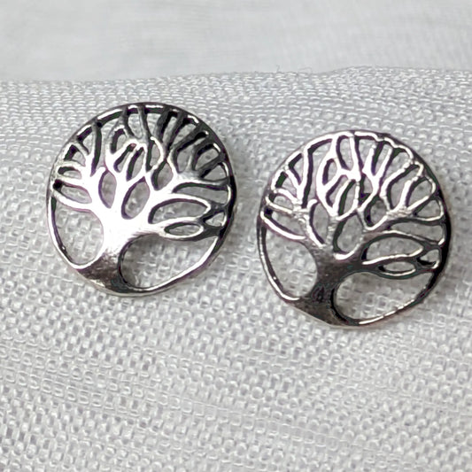 Nahaufnahme von zwei runden Lebensbaum-Ohrsteckern aus glänzendem 925 Sterling Silber mit filigraner Cut-out-Optik.