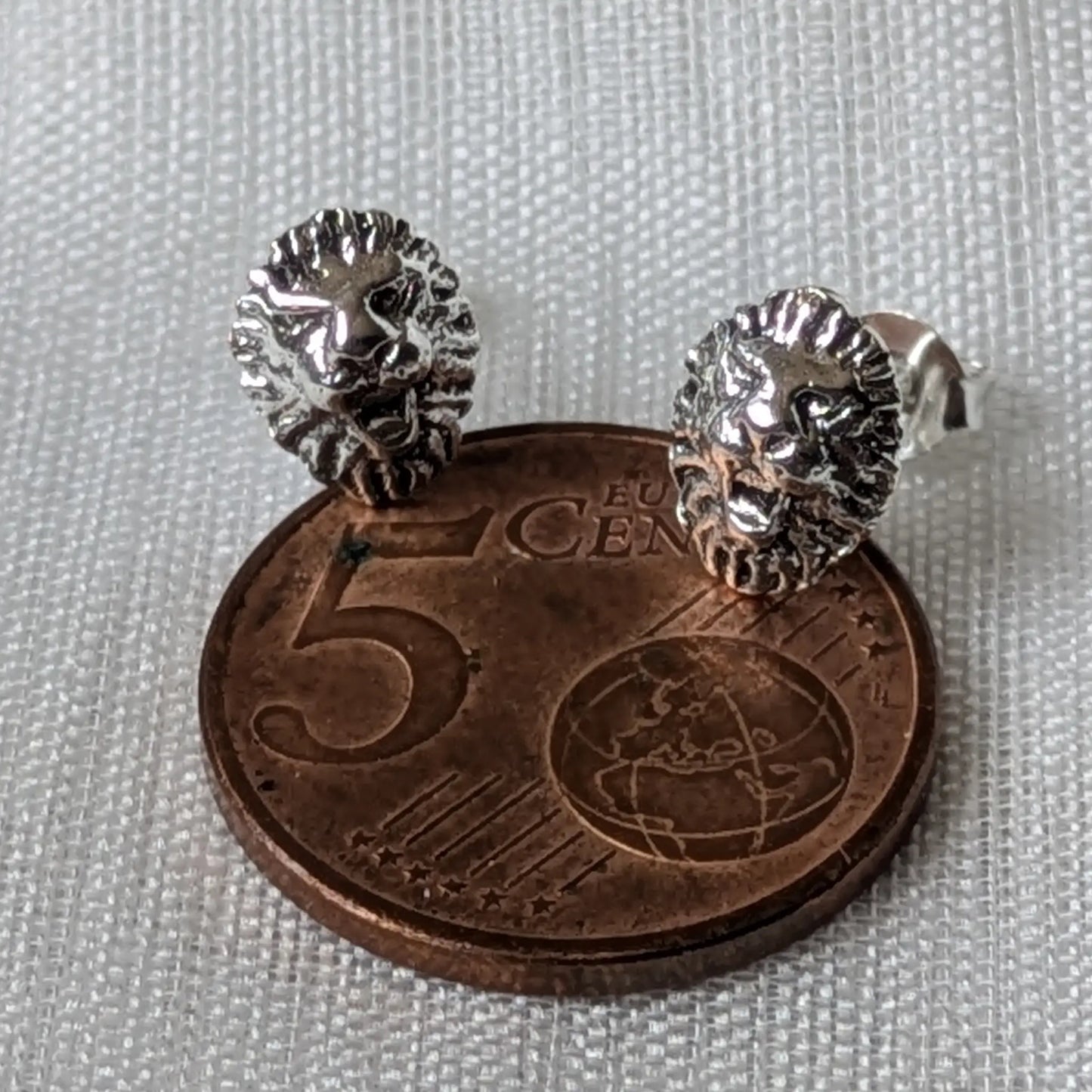 Größenvergleich: Der detailreiche Löwen Ohrstecker auf einer 5-Cent-Münze
