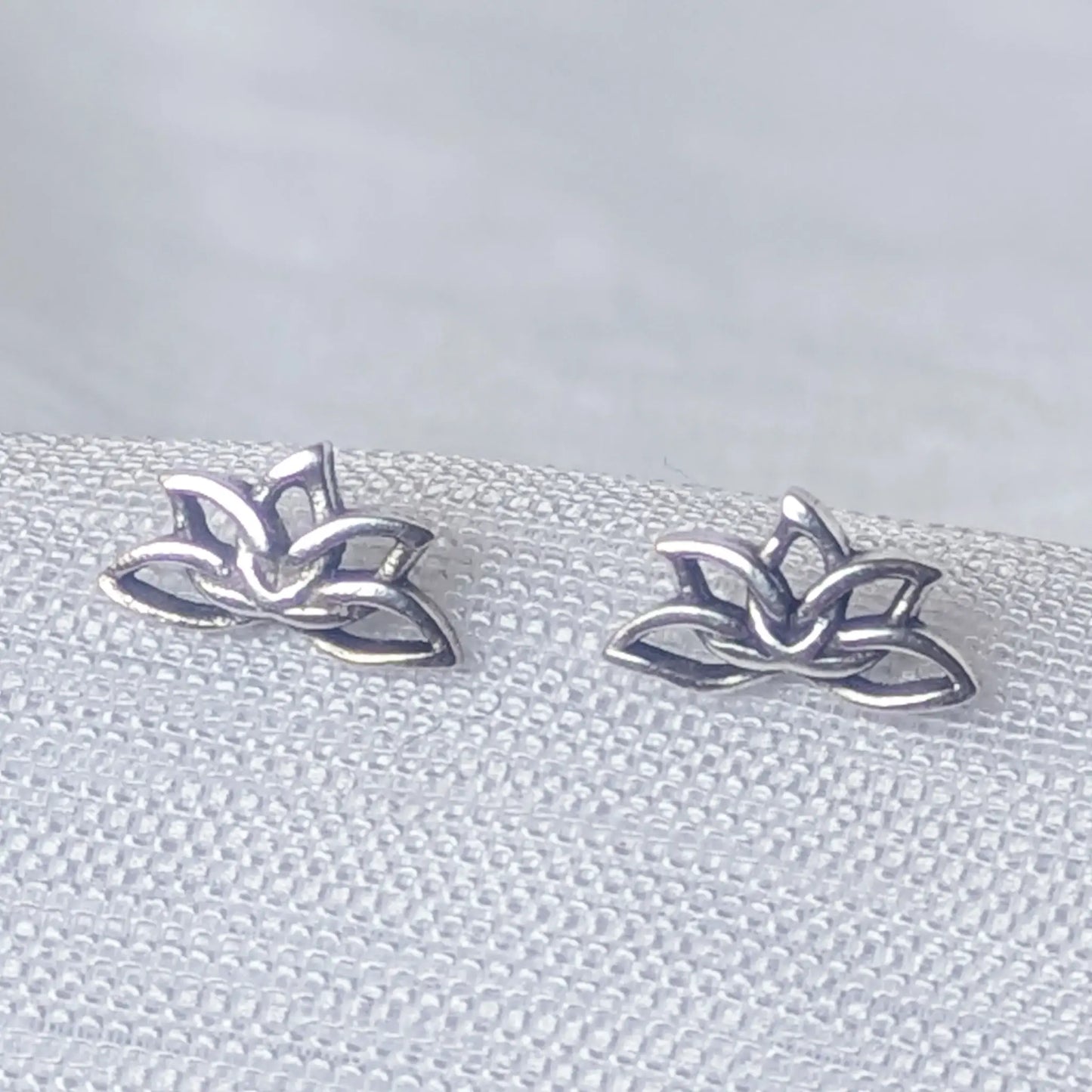 Detailreiche Nahaufnahme der Lotus Ohrstecker aus 925 Sterling Silber mit filigranem Cut-Out-Design.